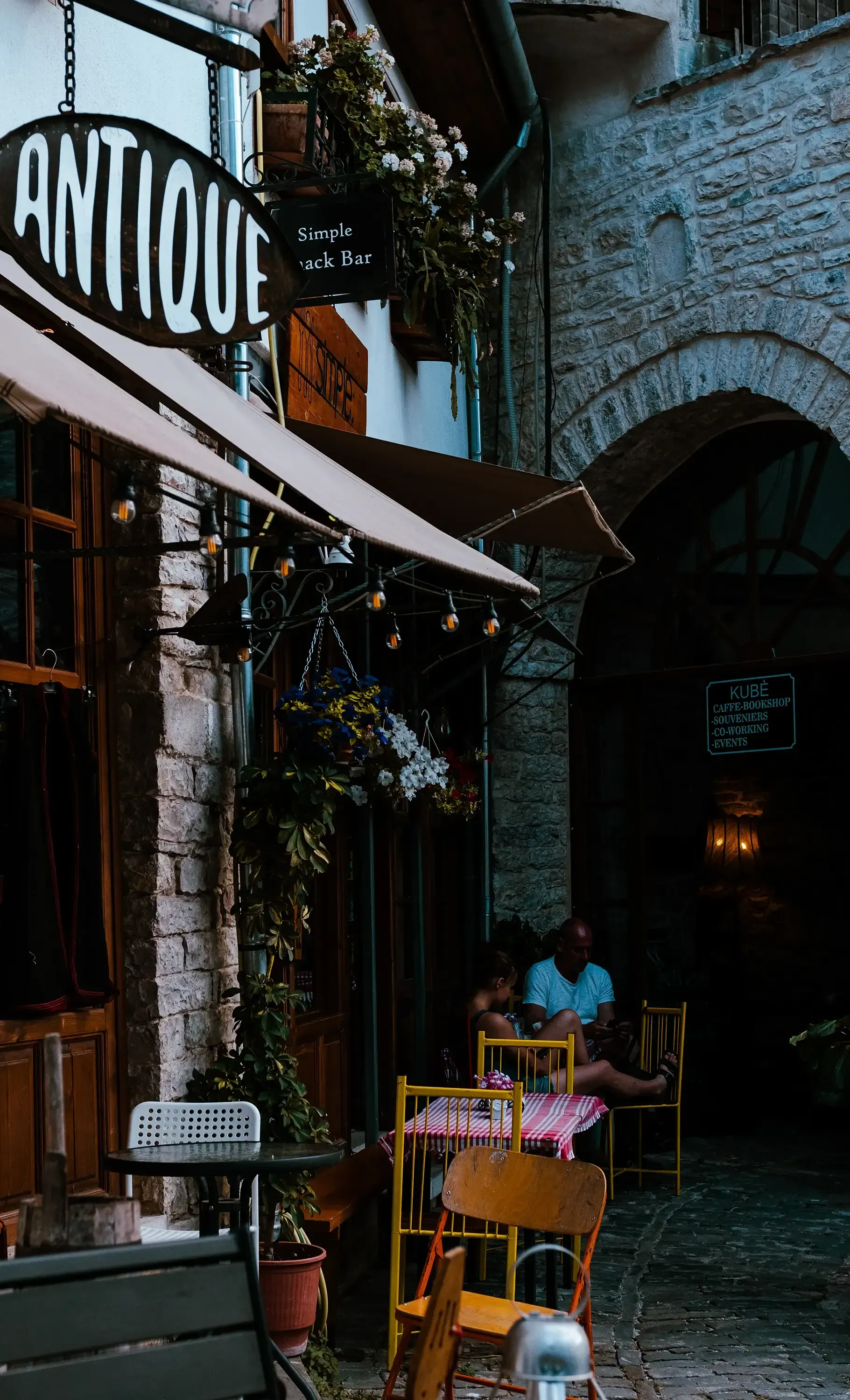 A coffee cup or cafe setting in a typical stone house street in the historic city of Berat.