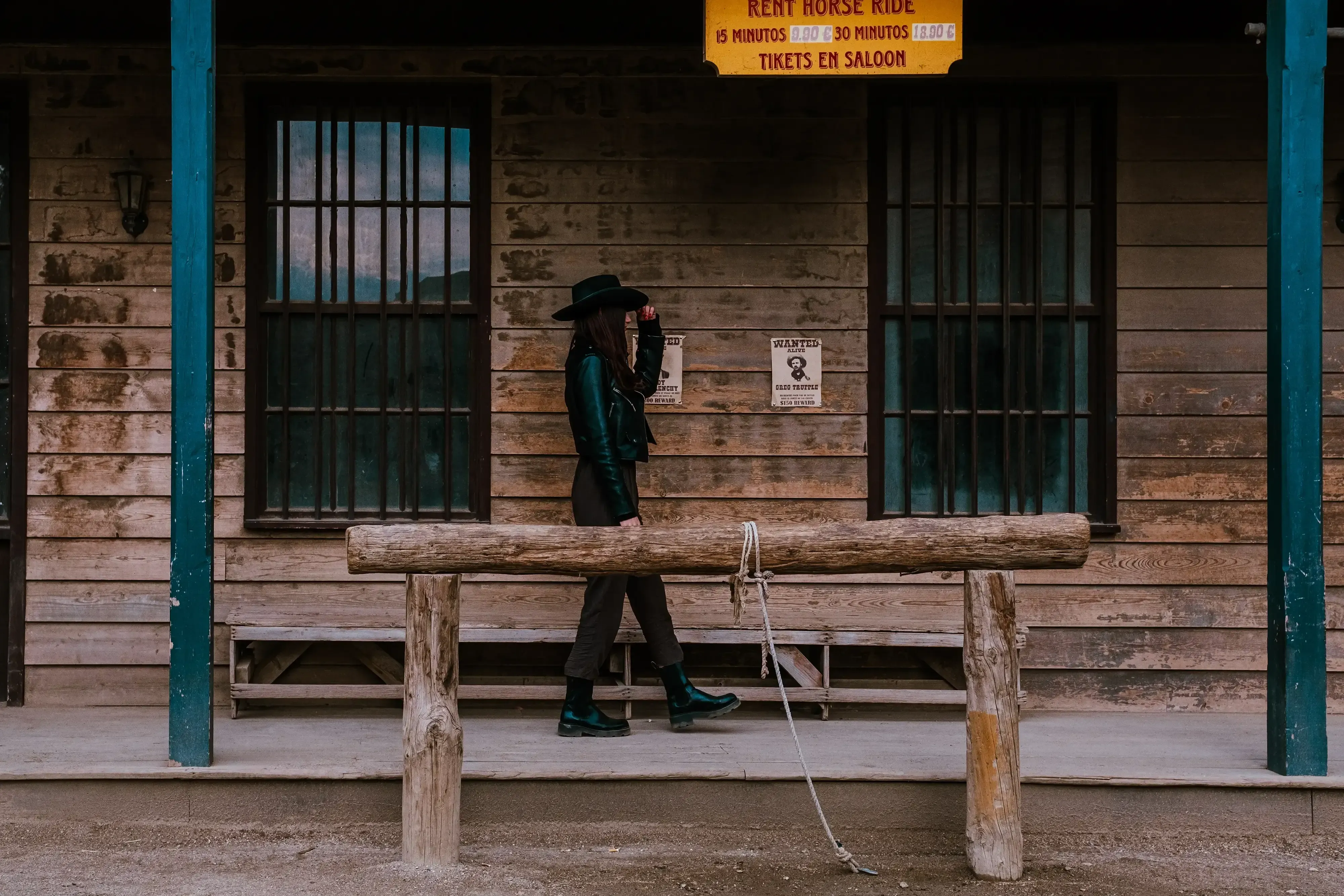 Miriam walking in front of the wooden jail or prison structure at Fort Bravo.