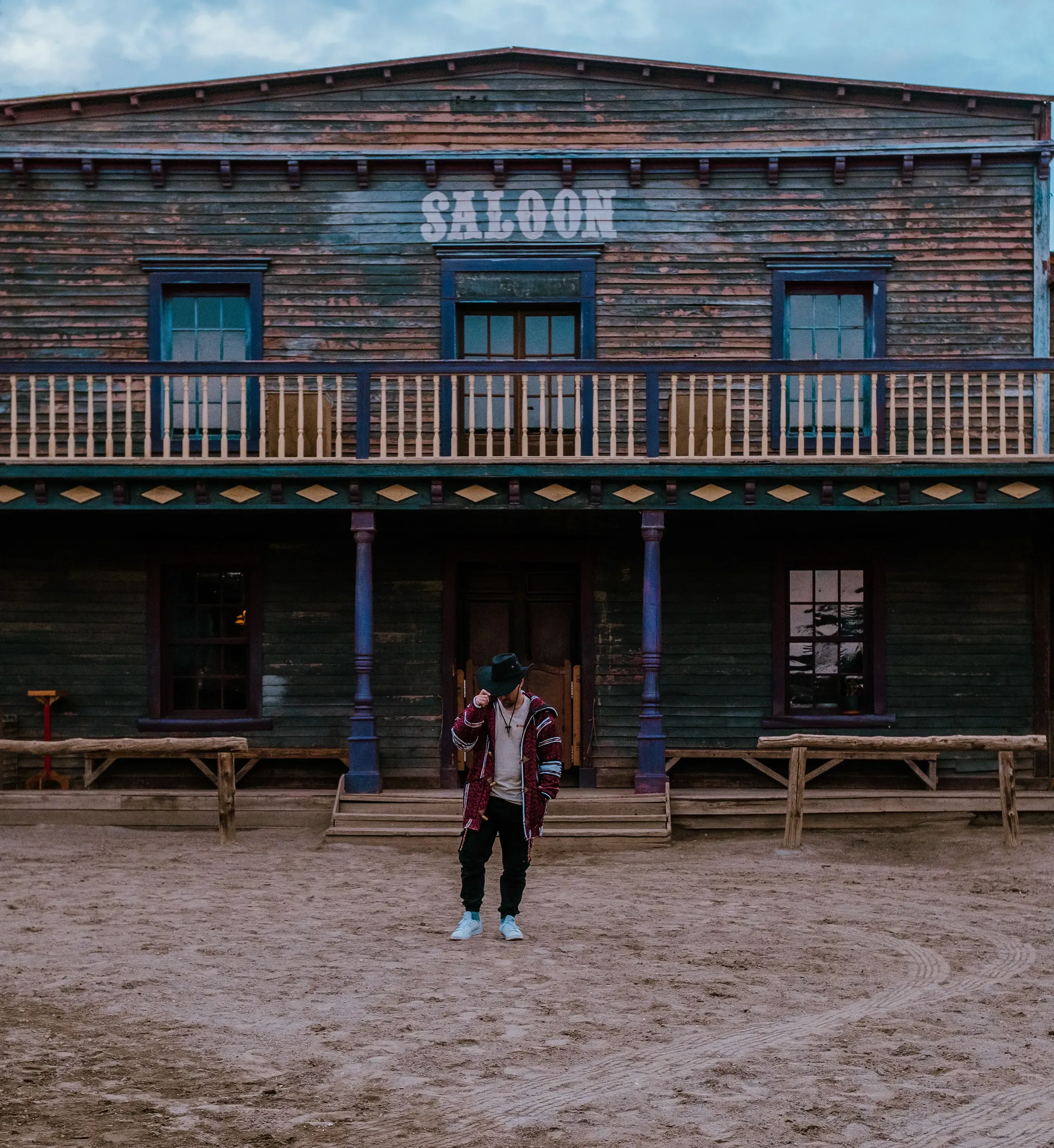 Ieser standing in front of the saloon wearing a cowboy hat.