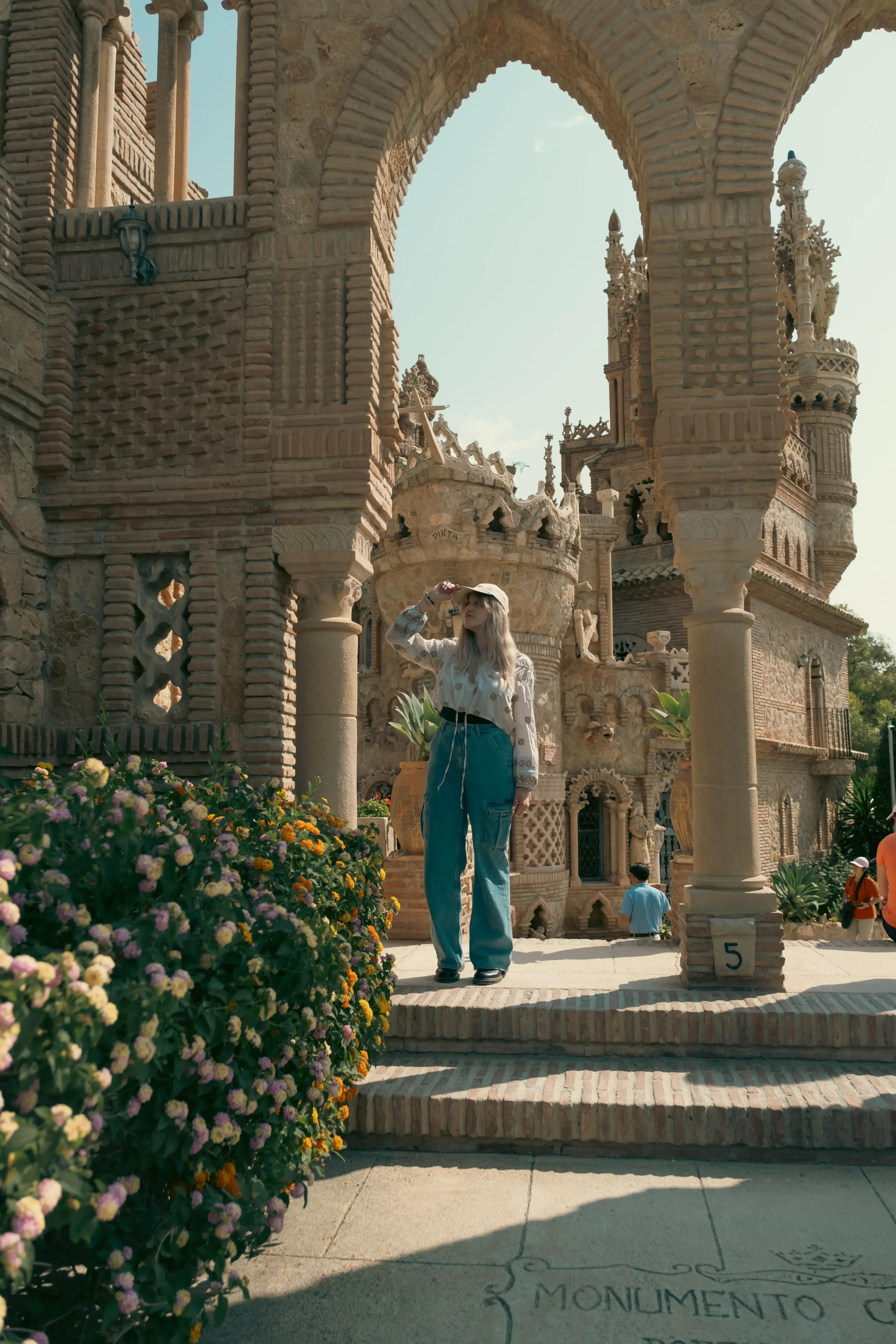 Letizia posing next to an intricate, decorative archway within the fairytale architecture of Castillo de Colomares.