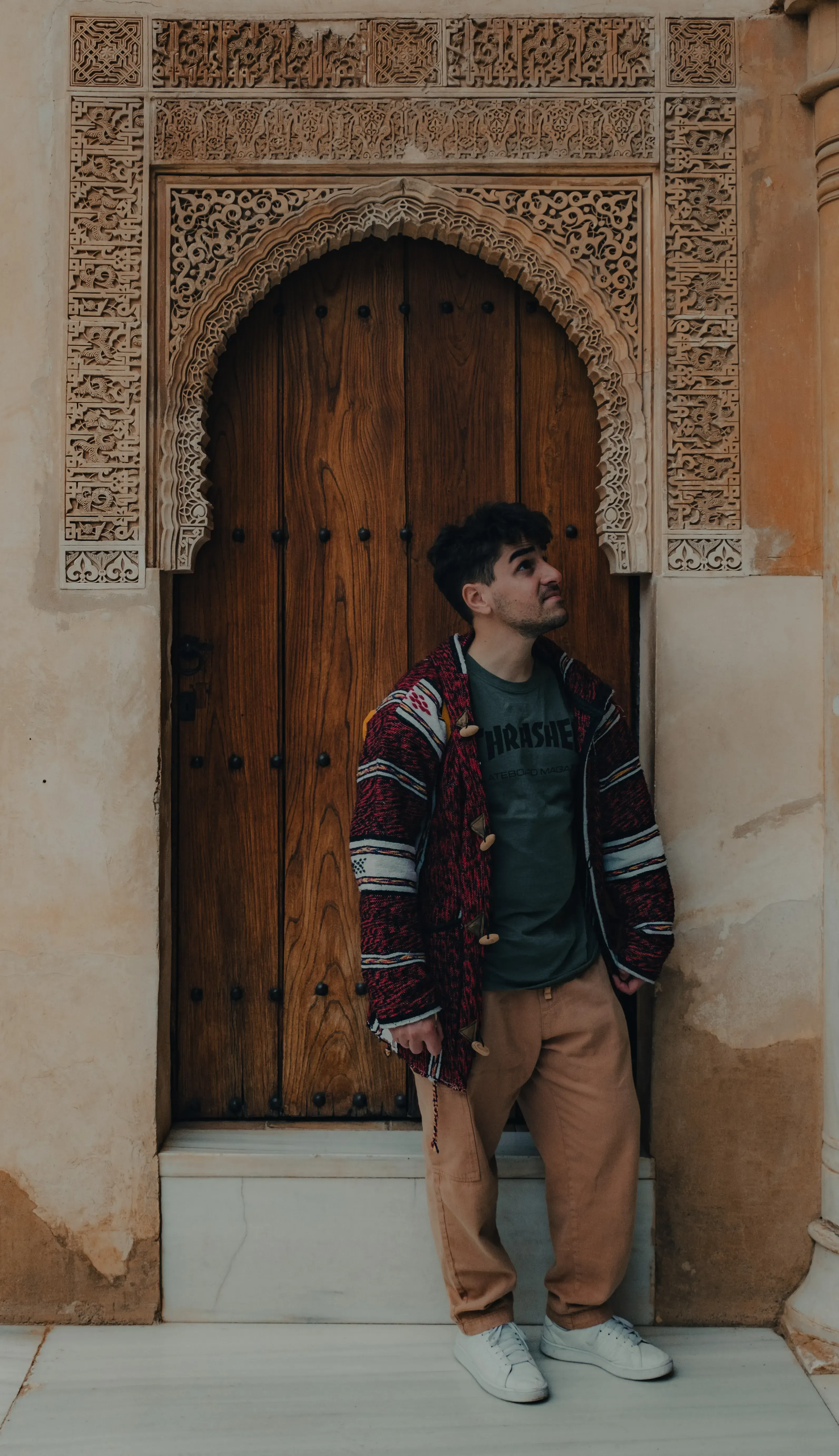 Ieser posing next to an intricate Moorish wooden door inside the Alcázar palace complex.