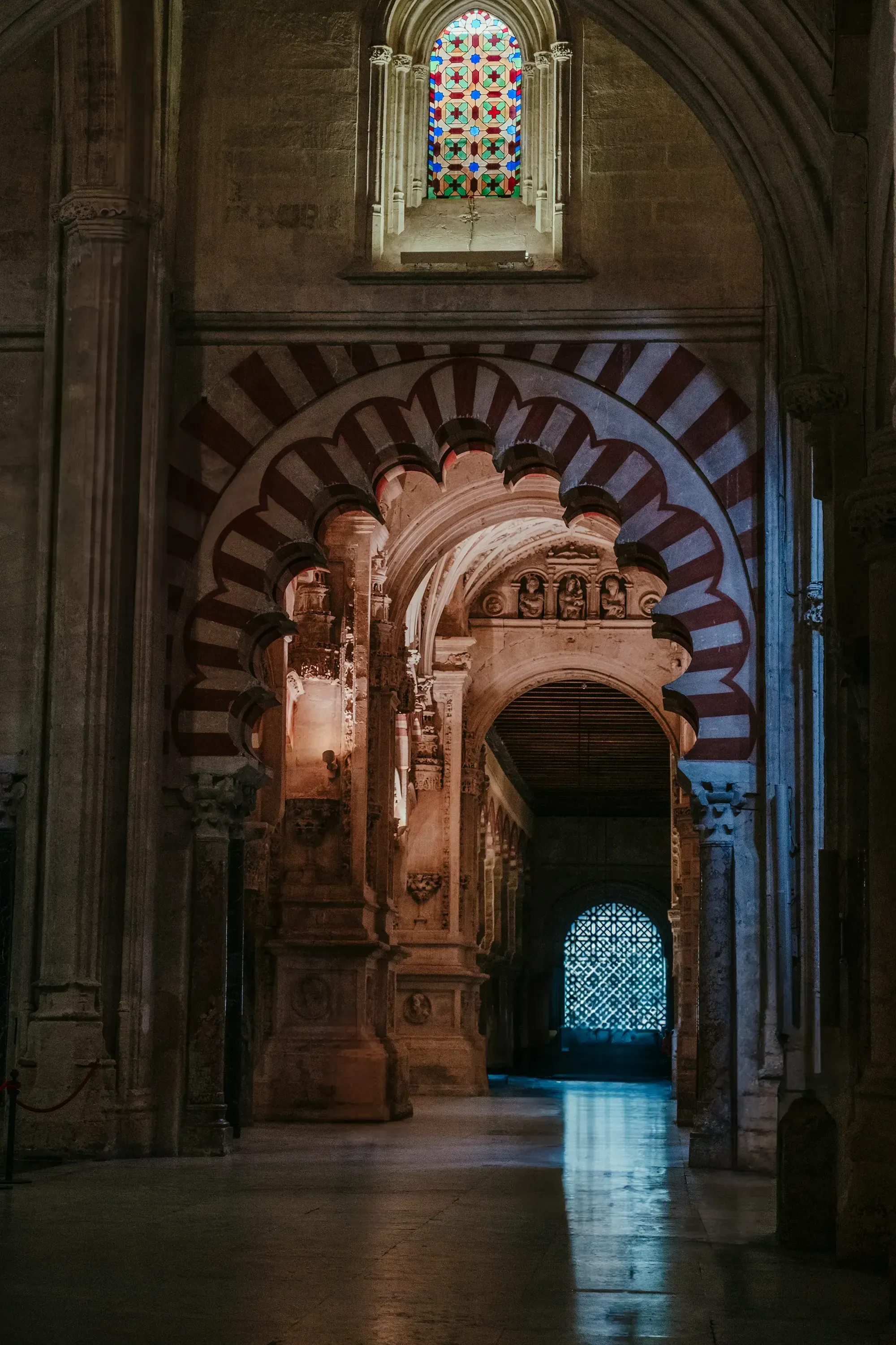 A view through one of the dramatic, red and white striped horseshoe arches inside the Mezquita-Cathedral of Córdoba.