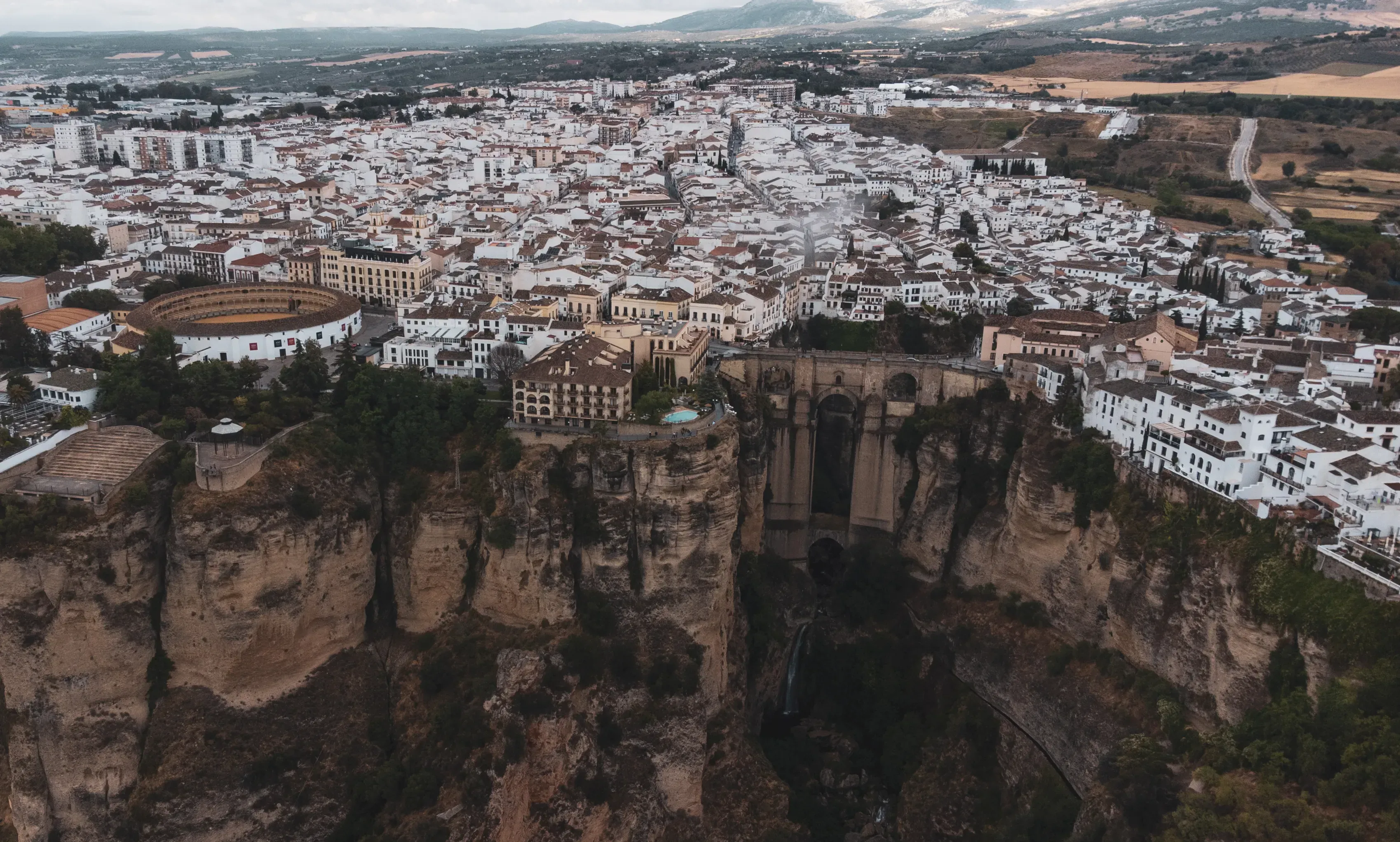 The monumental, tri-arch Puente Nuevo in Ronda, spanning the 100-meter-deep El Tajo gorge that dramatically divides the city.