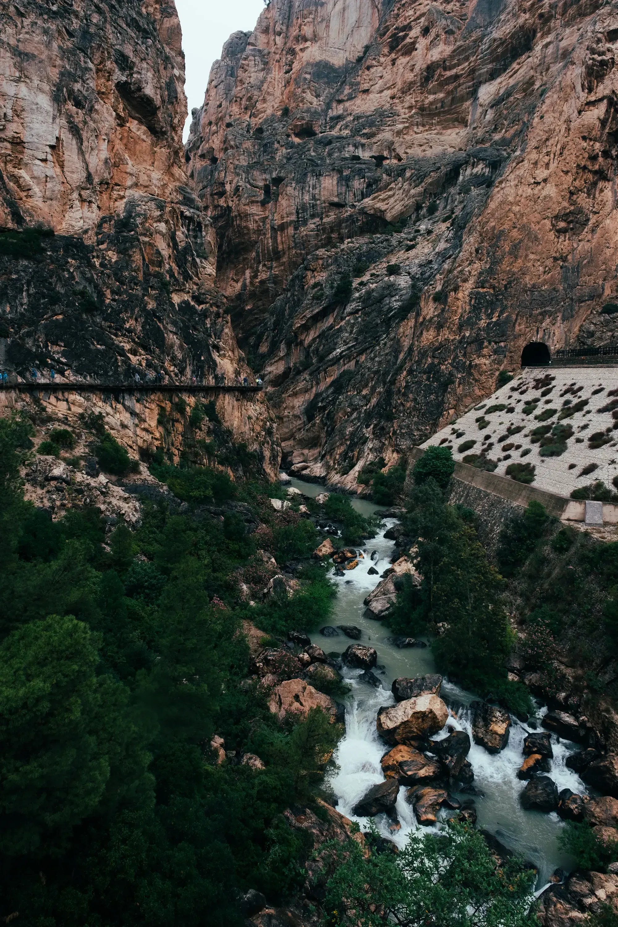 The turquoise waters of the Guadalhorce River flowing through the deep, carved canyon below the Caminito del Rey hiking trail.