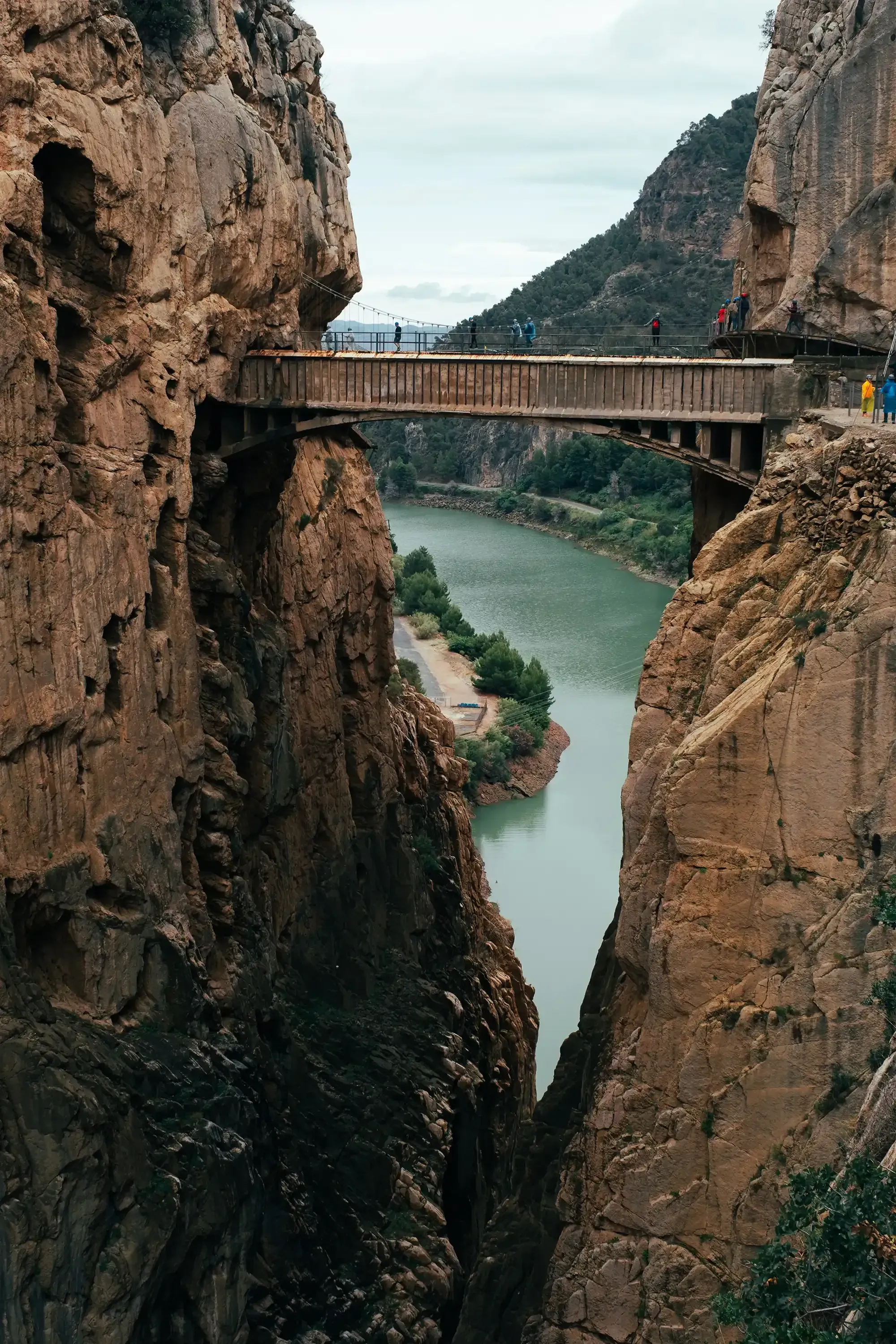 The final, narrow hanging bridge on the Caminito del Rey, a thrilling pathway suspended over the massive El Chorro gorge.