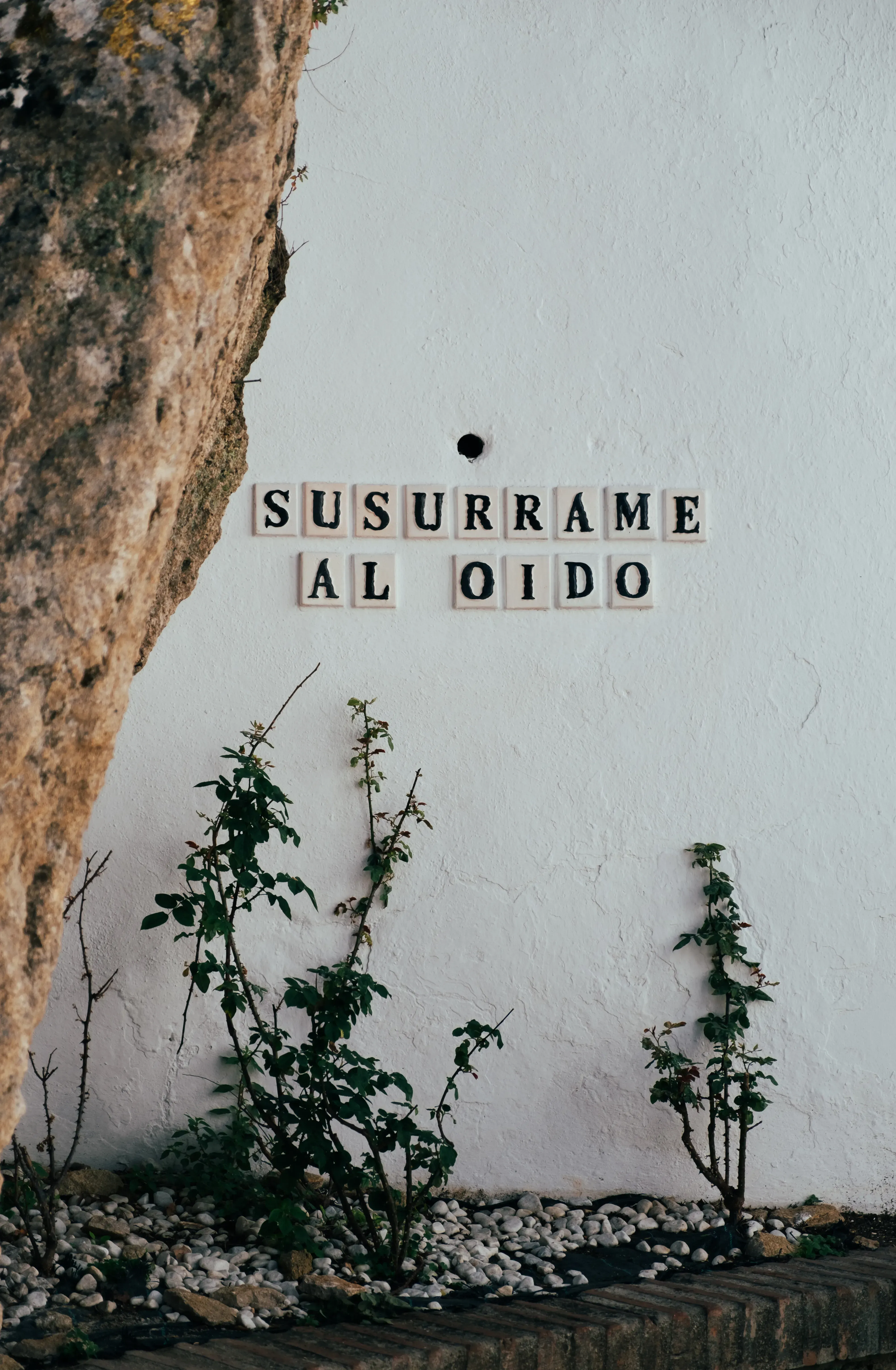 A phrase or inscription on the facade of a white house in Andalusia.