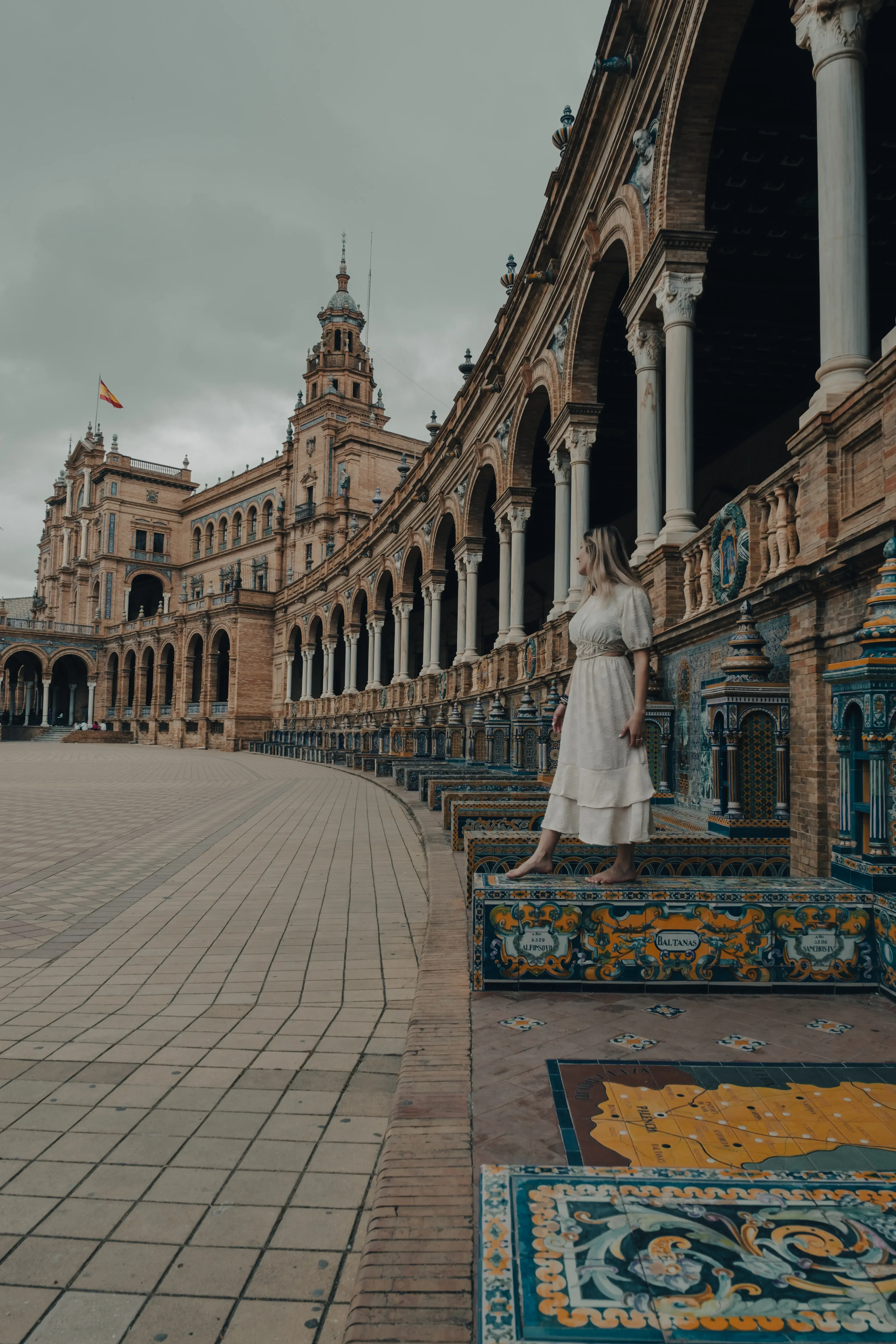 Letizia walking or balancing on one of the decorative ceramic benches in Plaza de España.