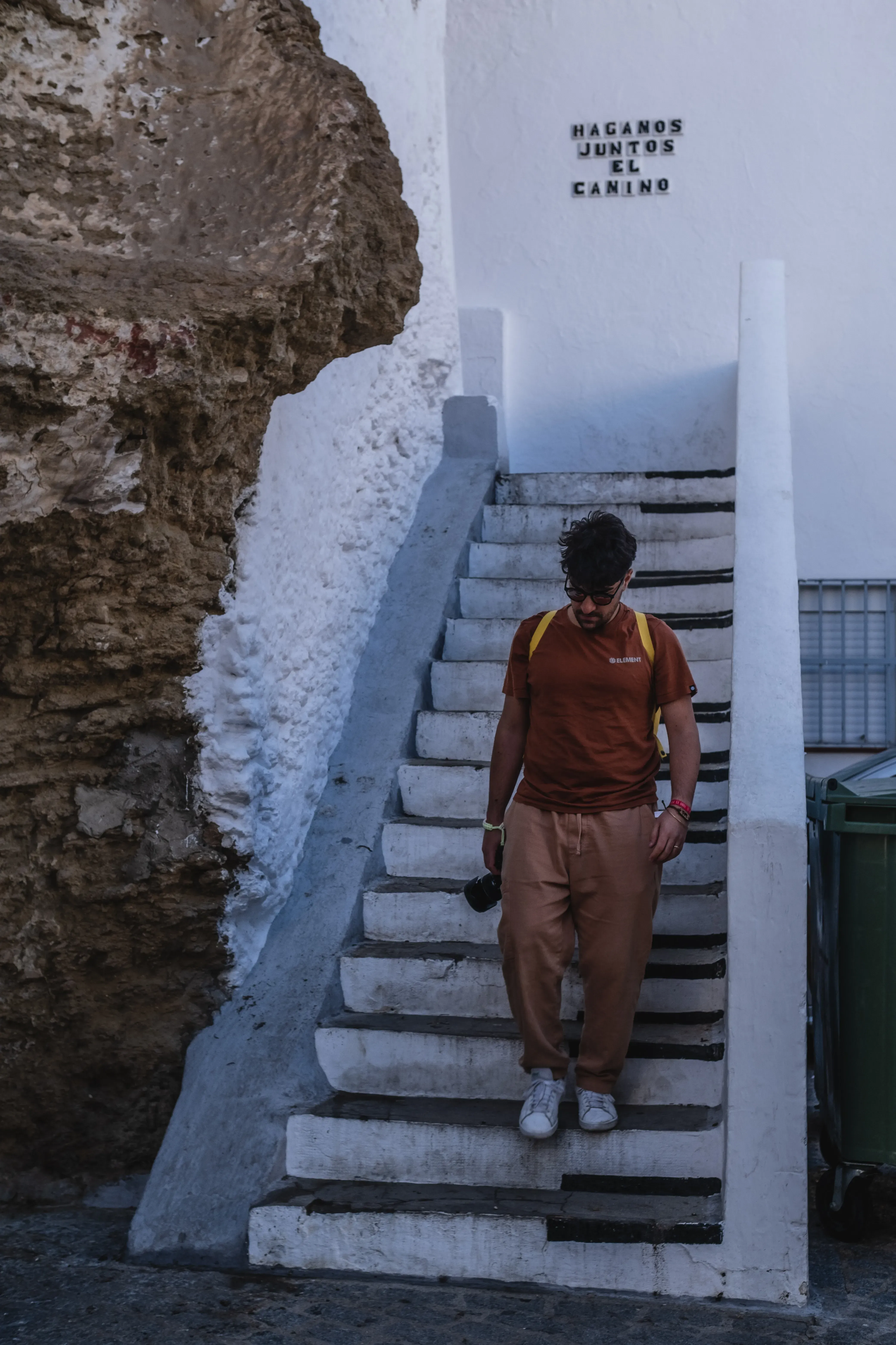 Ieser descending a set of stairs in the white village of Setenil de las Bodegas.