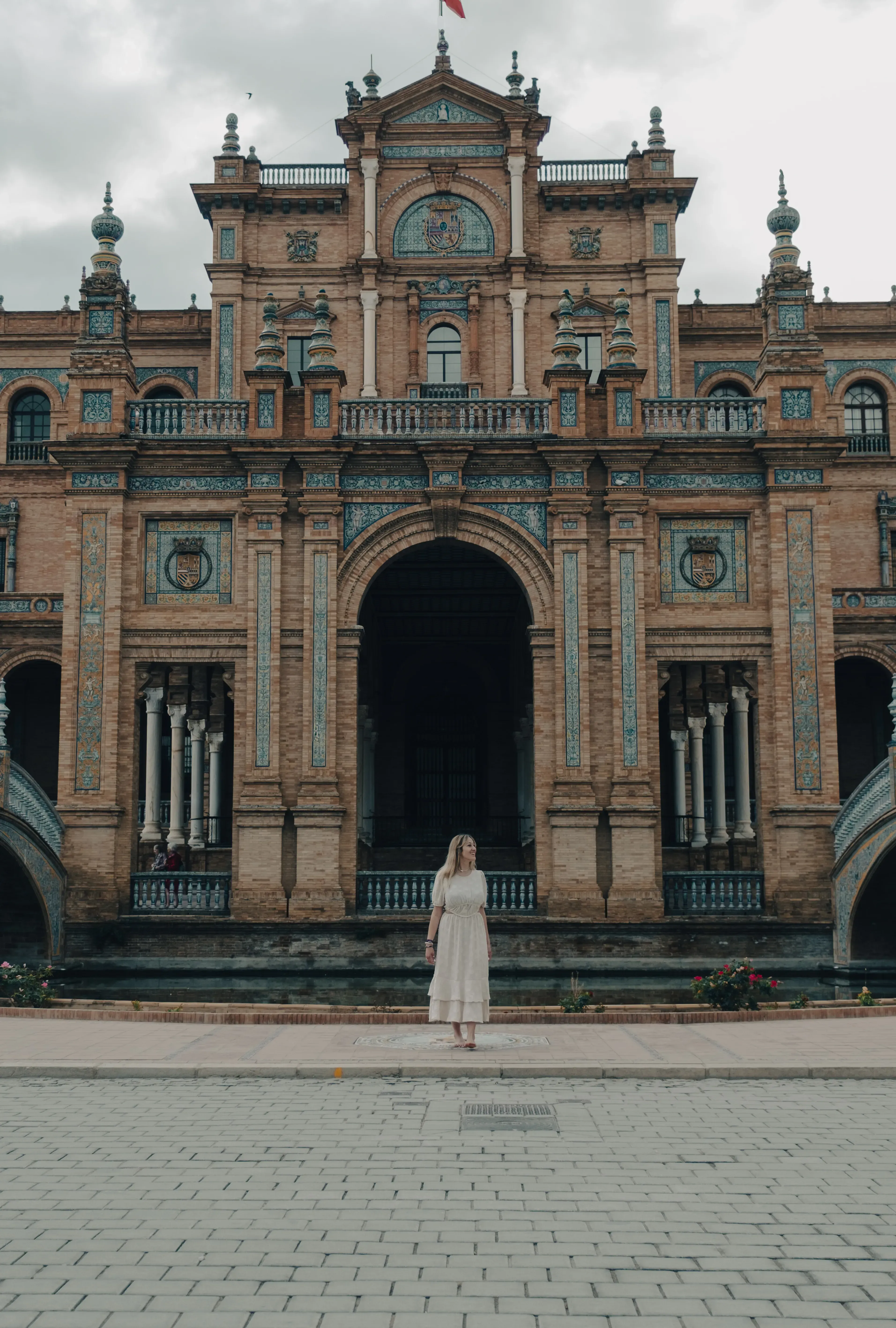Letizia standing among the elaborate ceramic benches and arches of the Plaza de España in Seville.