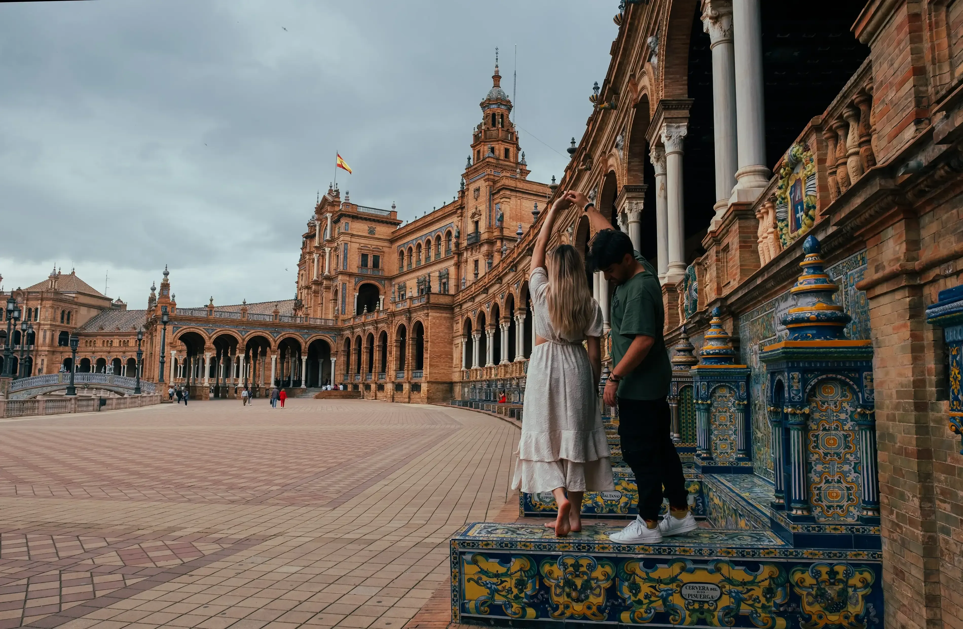 Ieser and Letizia posing together in the stunning, tiled architectural complex of Plaza de España in Seville.