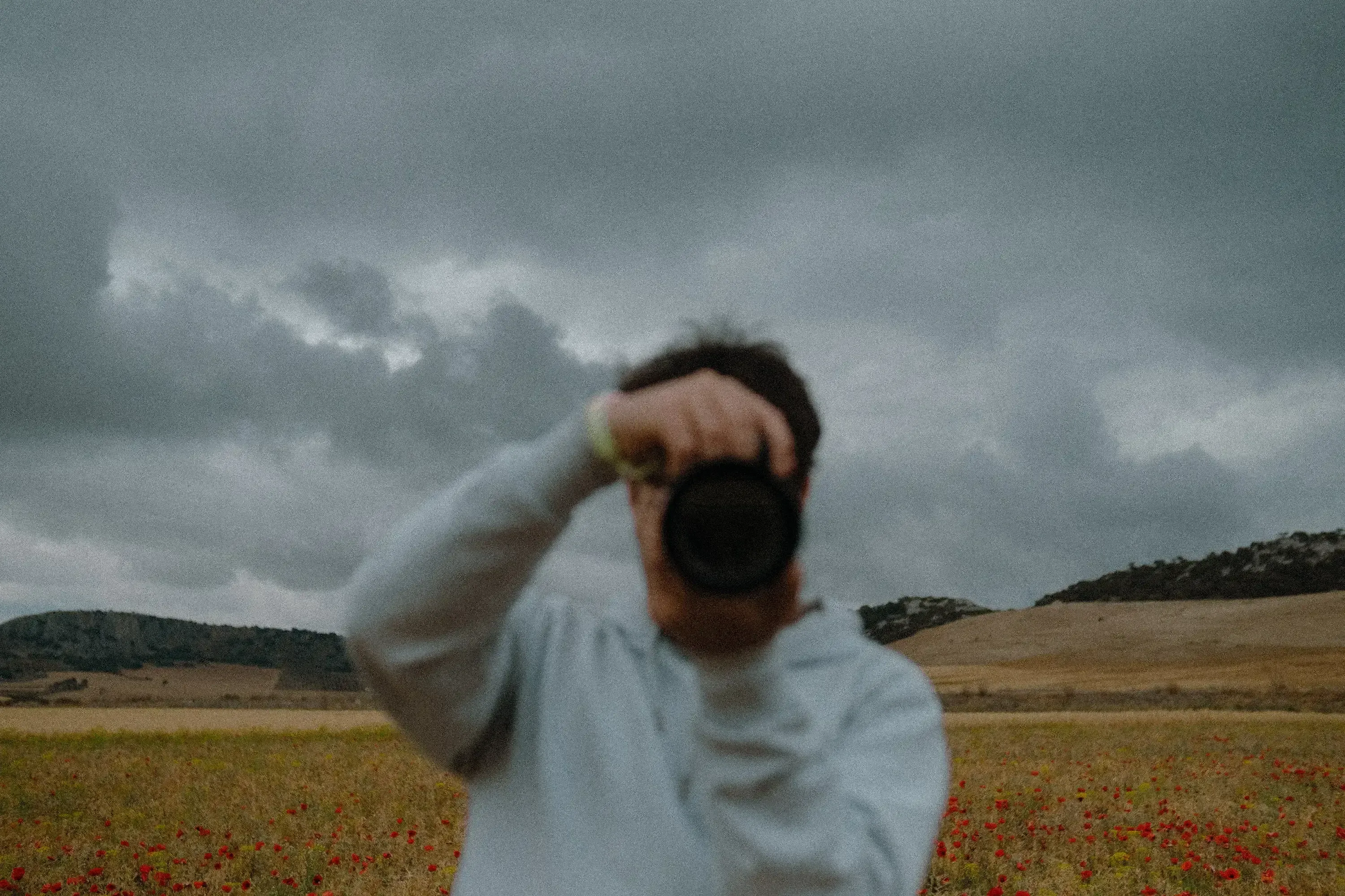 Ieser taking a photograph amidst the rolling, sun-drenched fields of Andalusia.