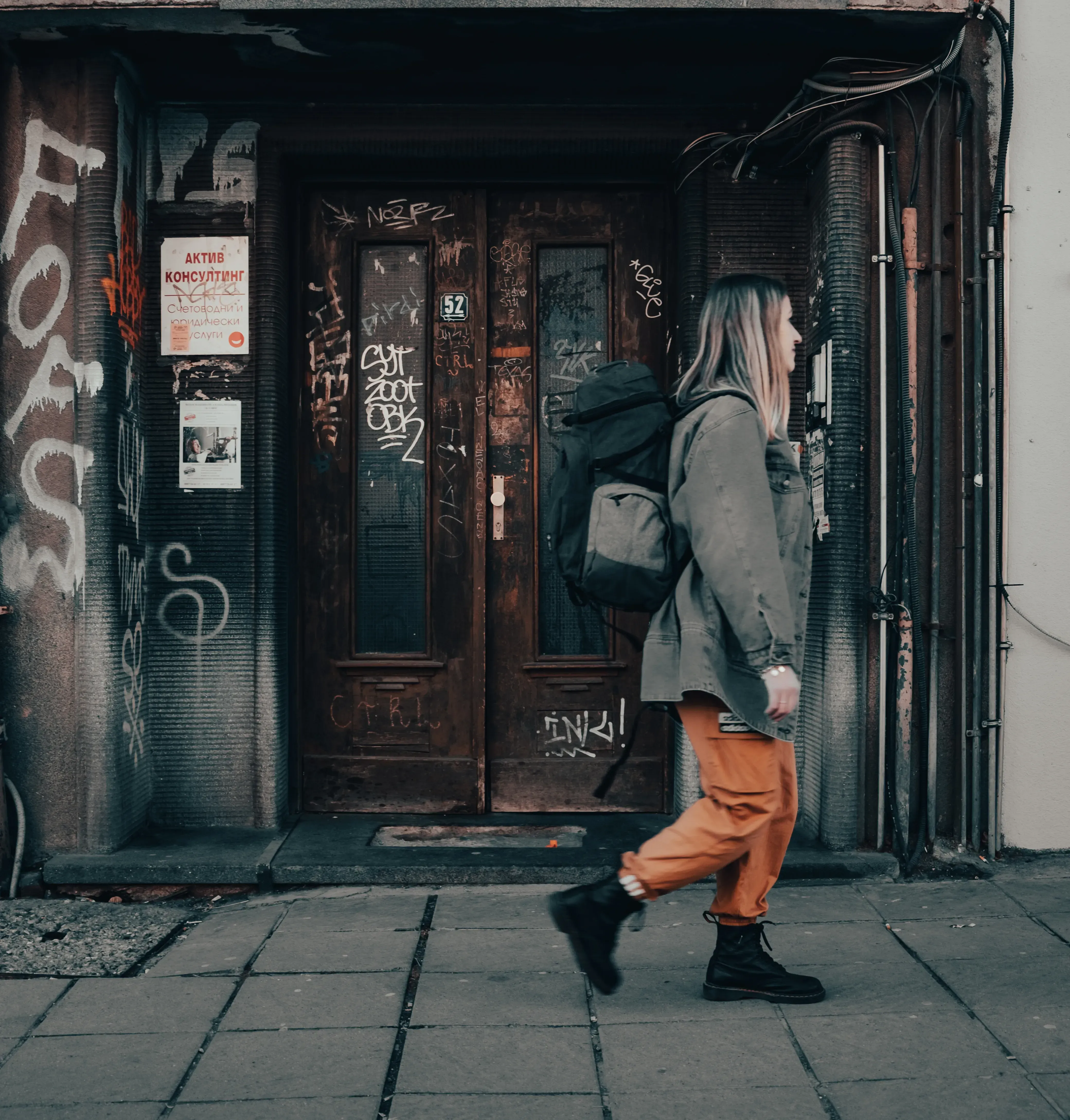 Letizia walking past a doorway on a street in Sofia.