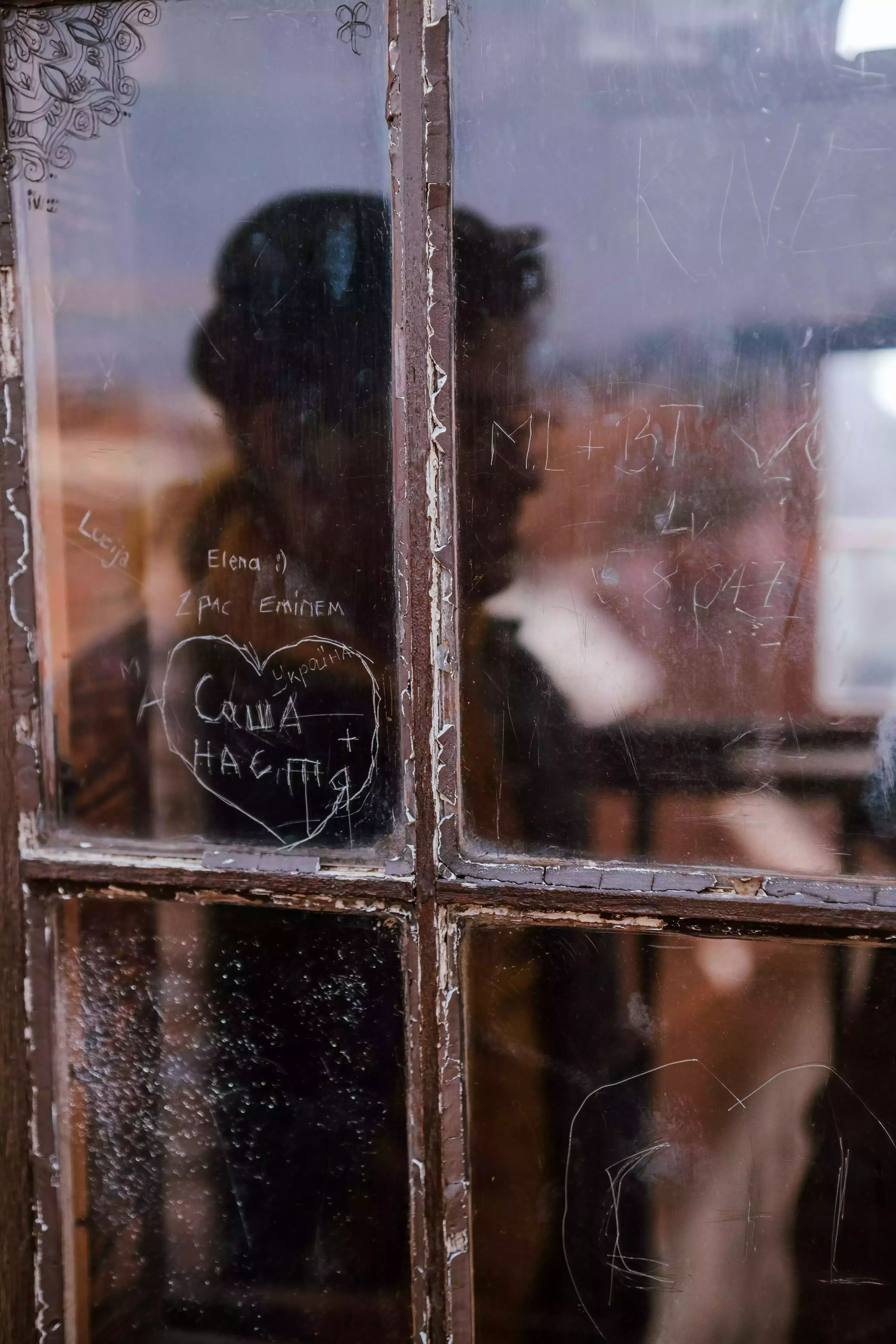 Person's reflection visible in the glass pane of a window in the city of Zagreb.