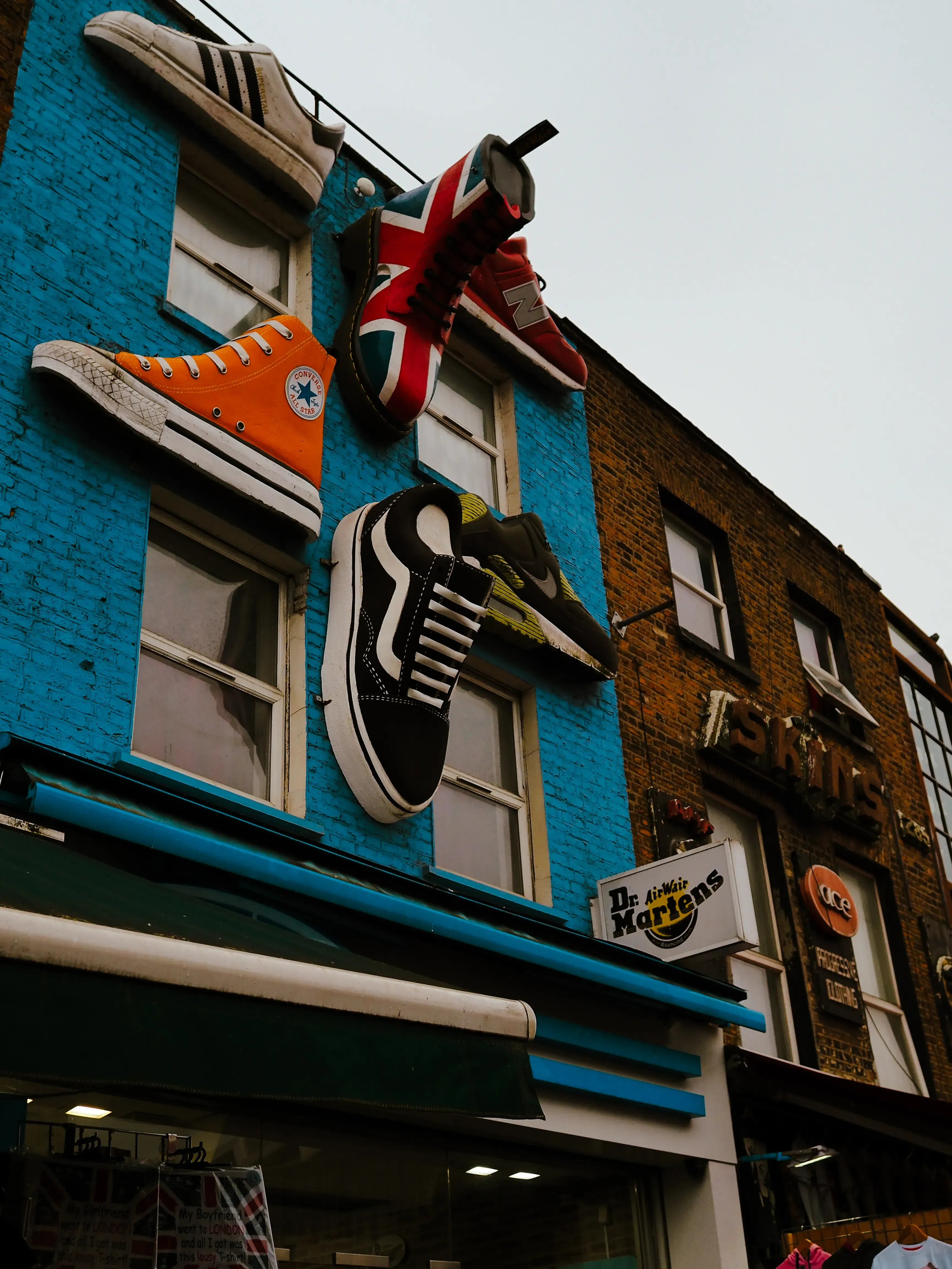 The distinctive vintage shoe sign hanging above a storefront entrance in Camden Town.