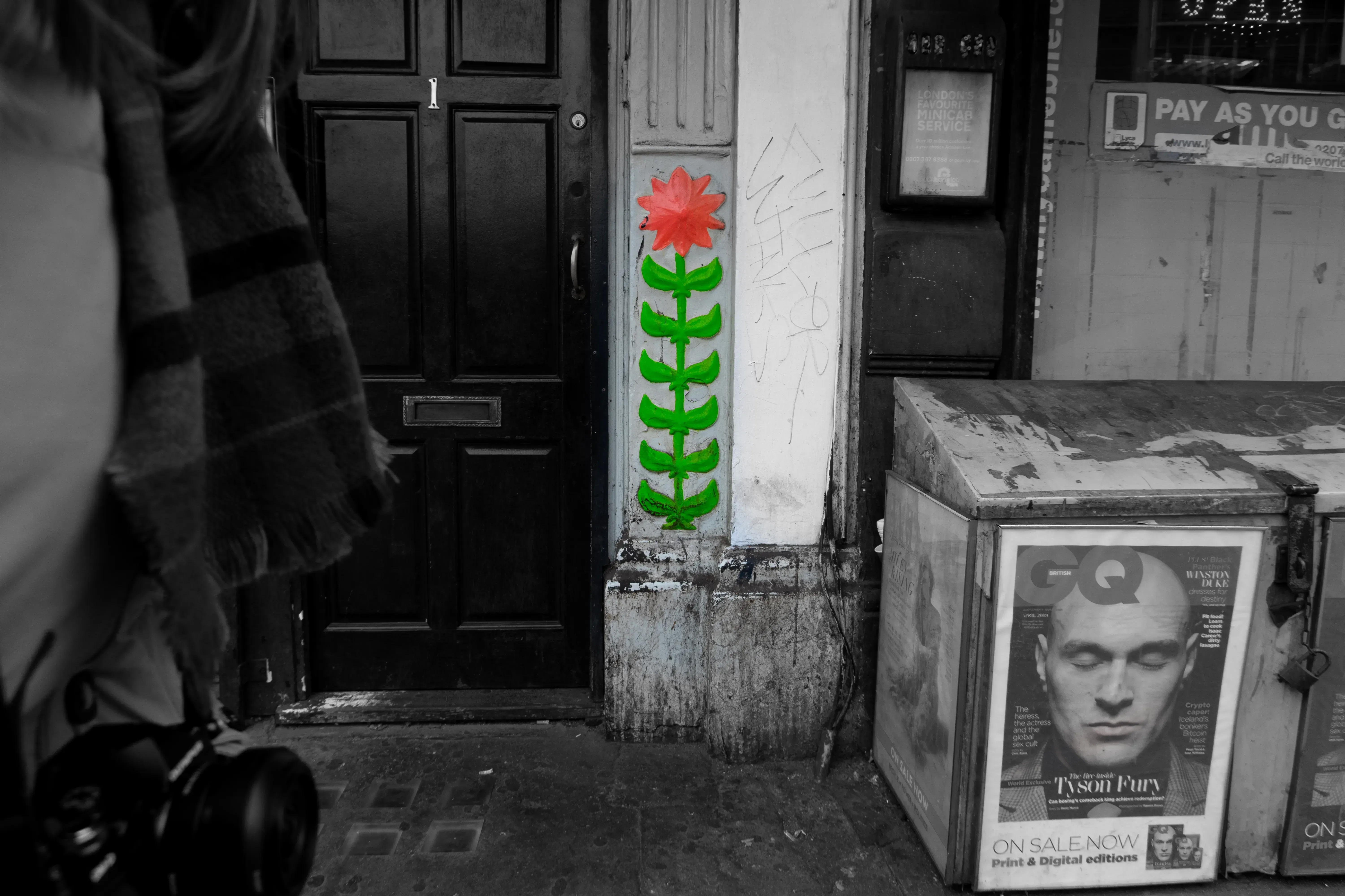 Black and white photograph of a large green and pink flower graffiti mural.