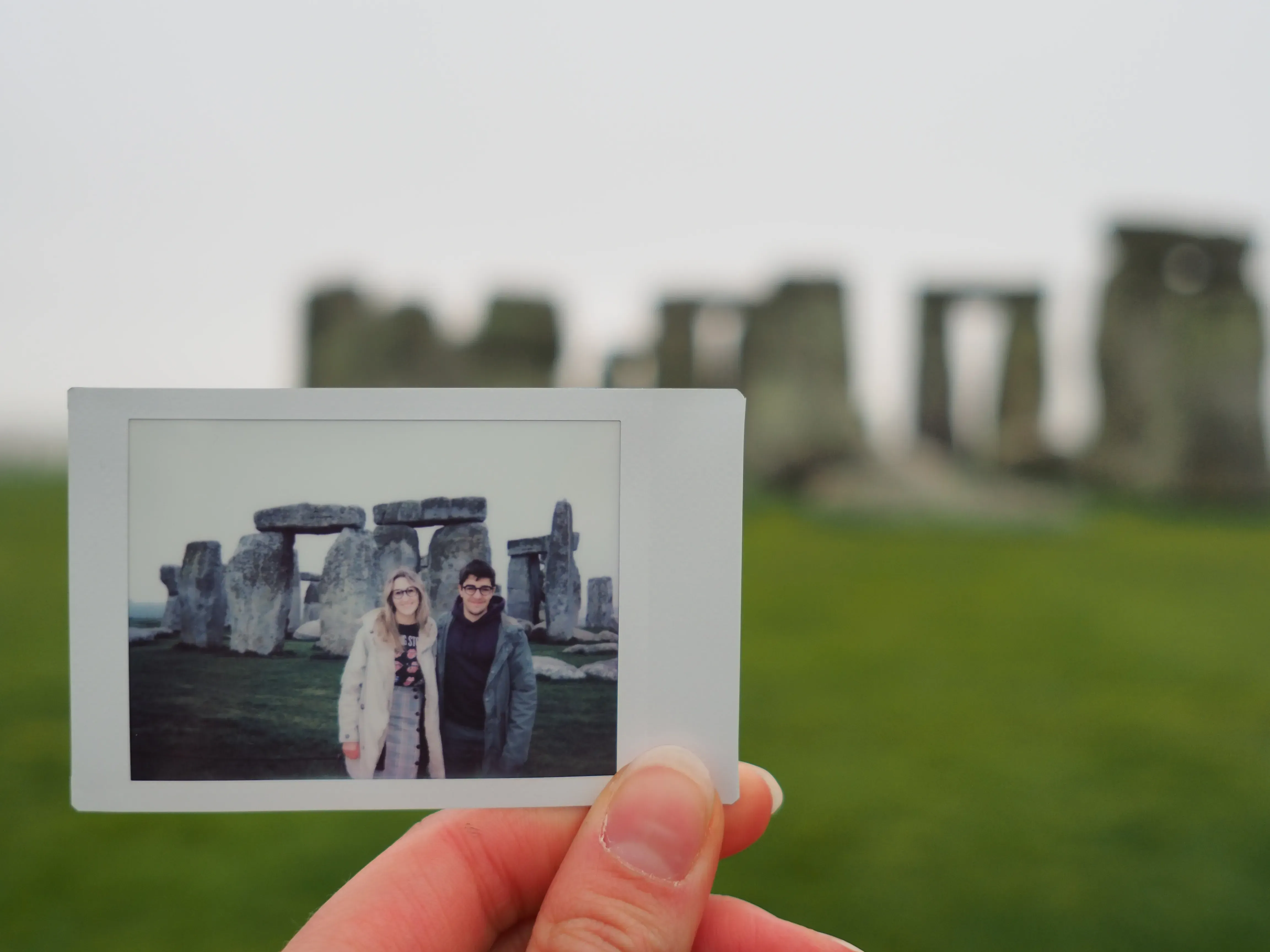 A Polaroid photo with showing Stonehenge visible clearly in the background.