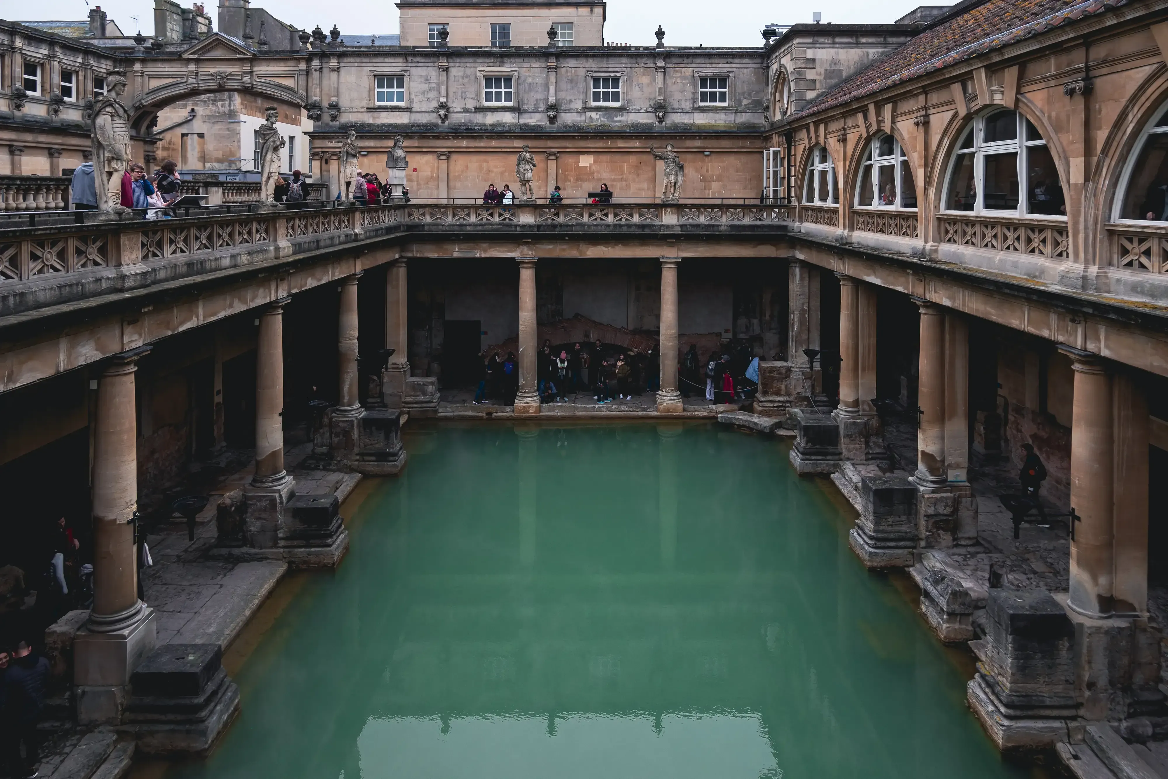 The large, turquoise-colored Great Bath pool at the historic Roman Baths complex