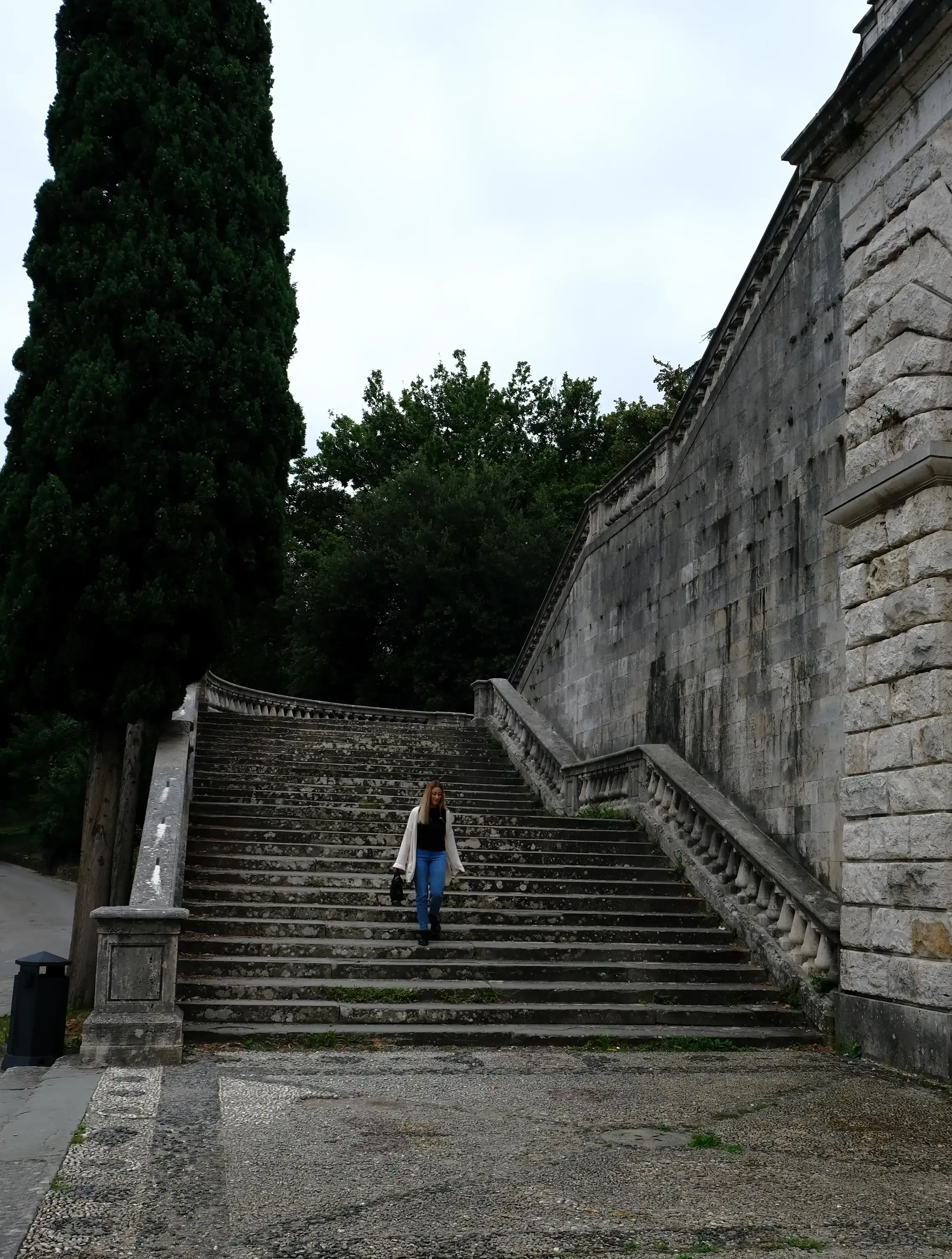 Letizia descending a wide, stone staircase in the city of Florence.