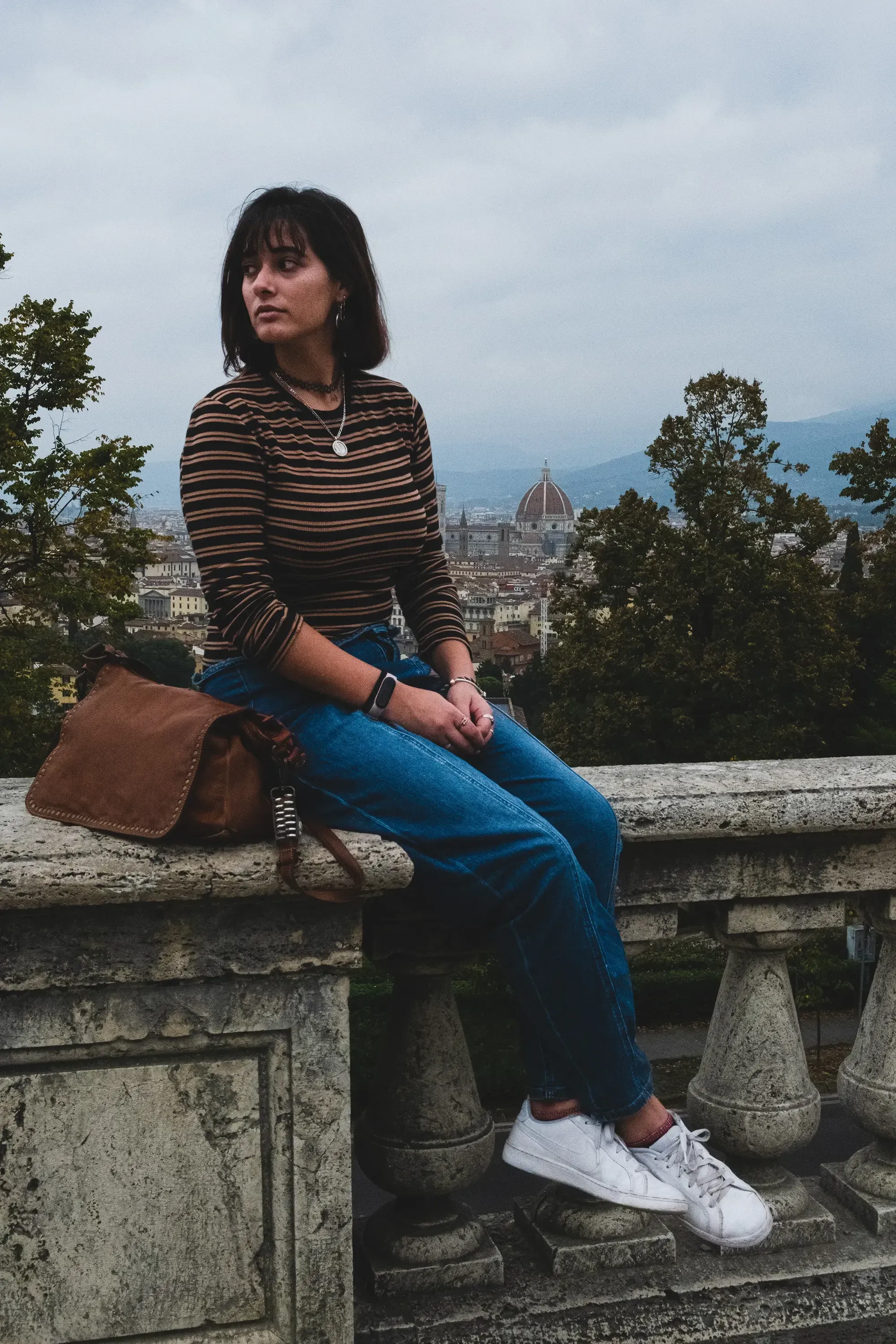 Paulina sitting on a decorative railing overlooking the Florentine cityscape."