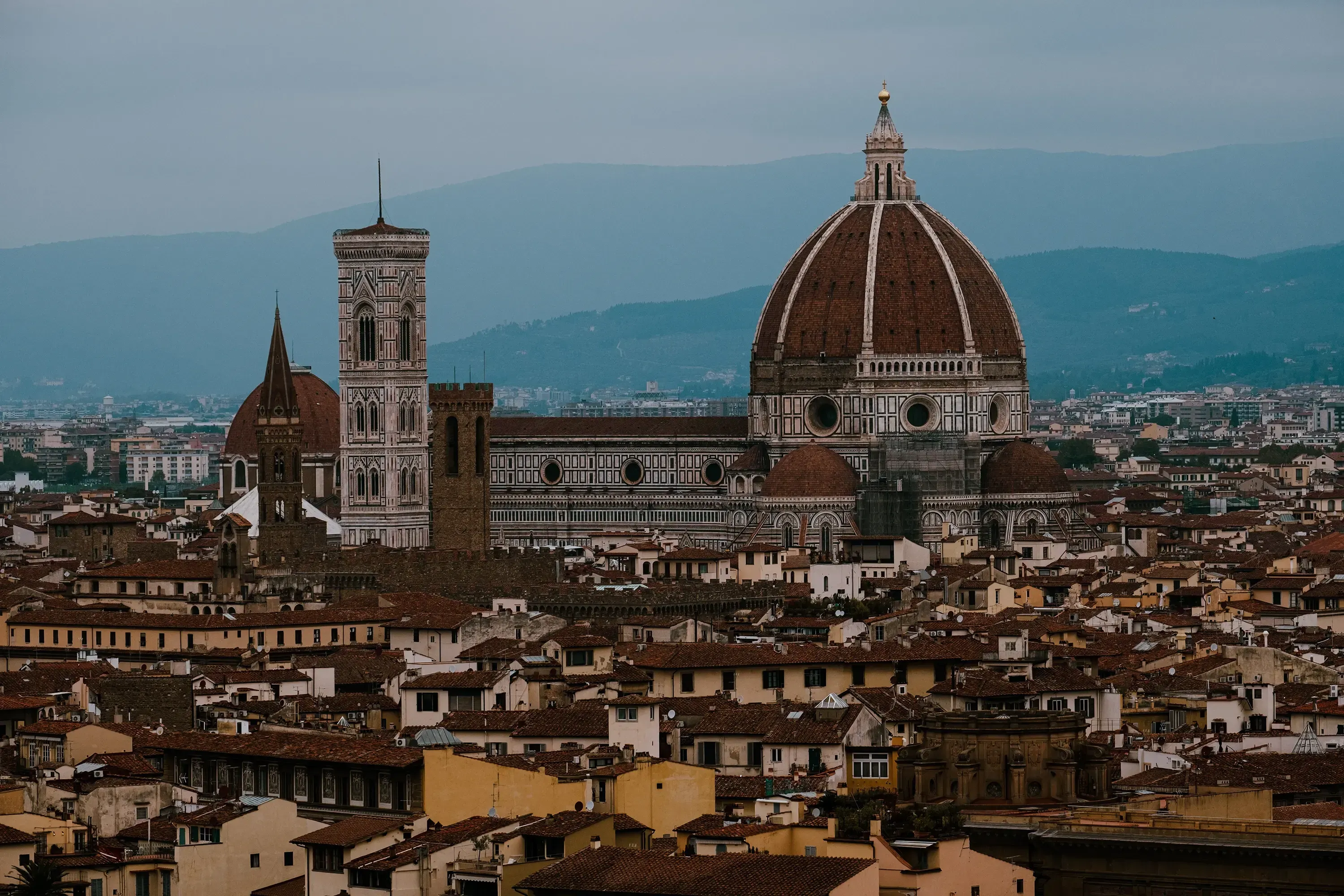 Distant view of the Florence Duomo, showing Brunelleschi's iconic dome rising above the city skyline.