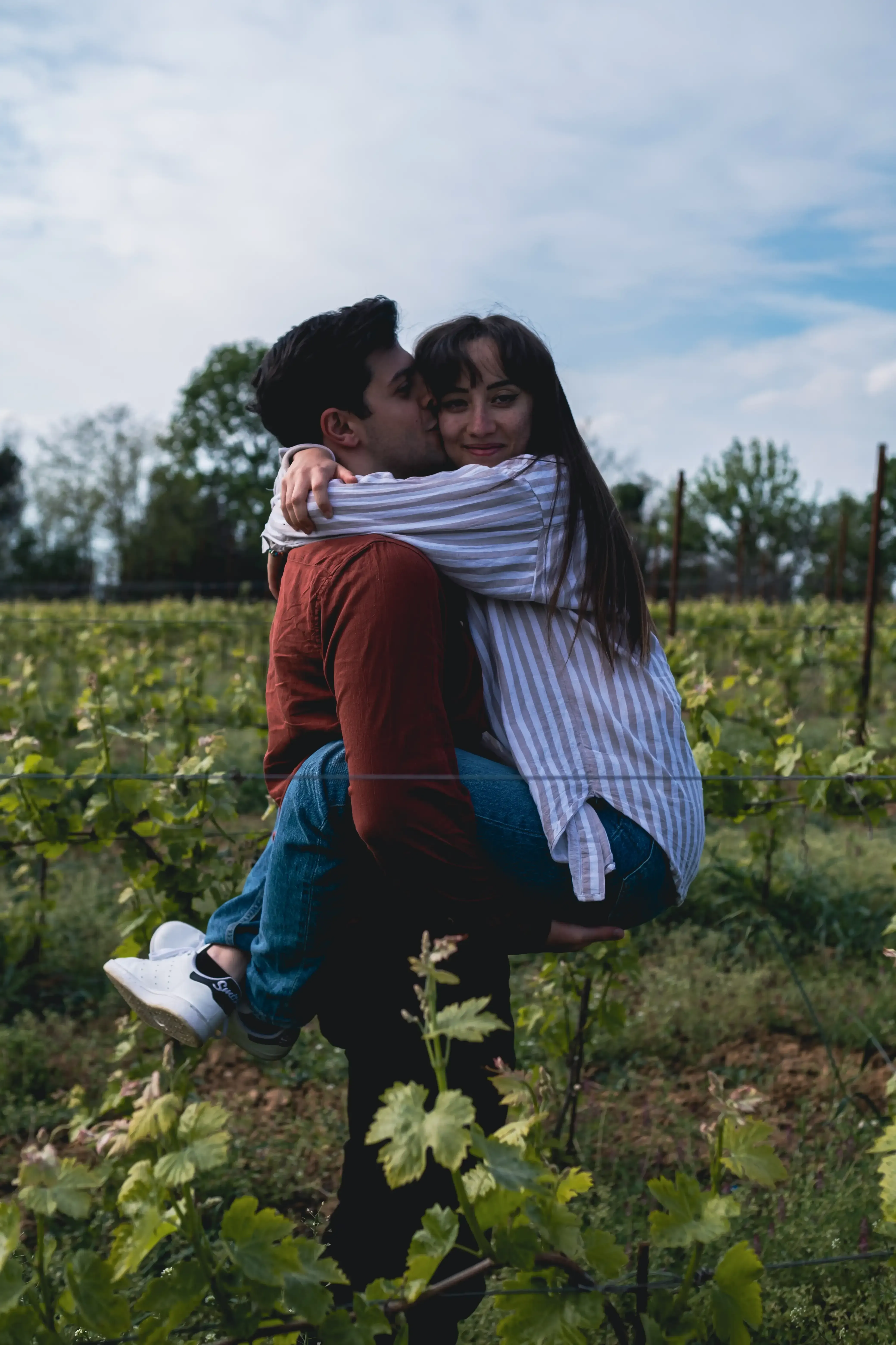 Giuseppe and Indya hugging in a vineyard