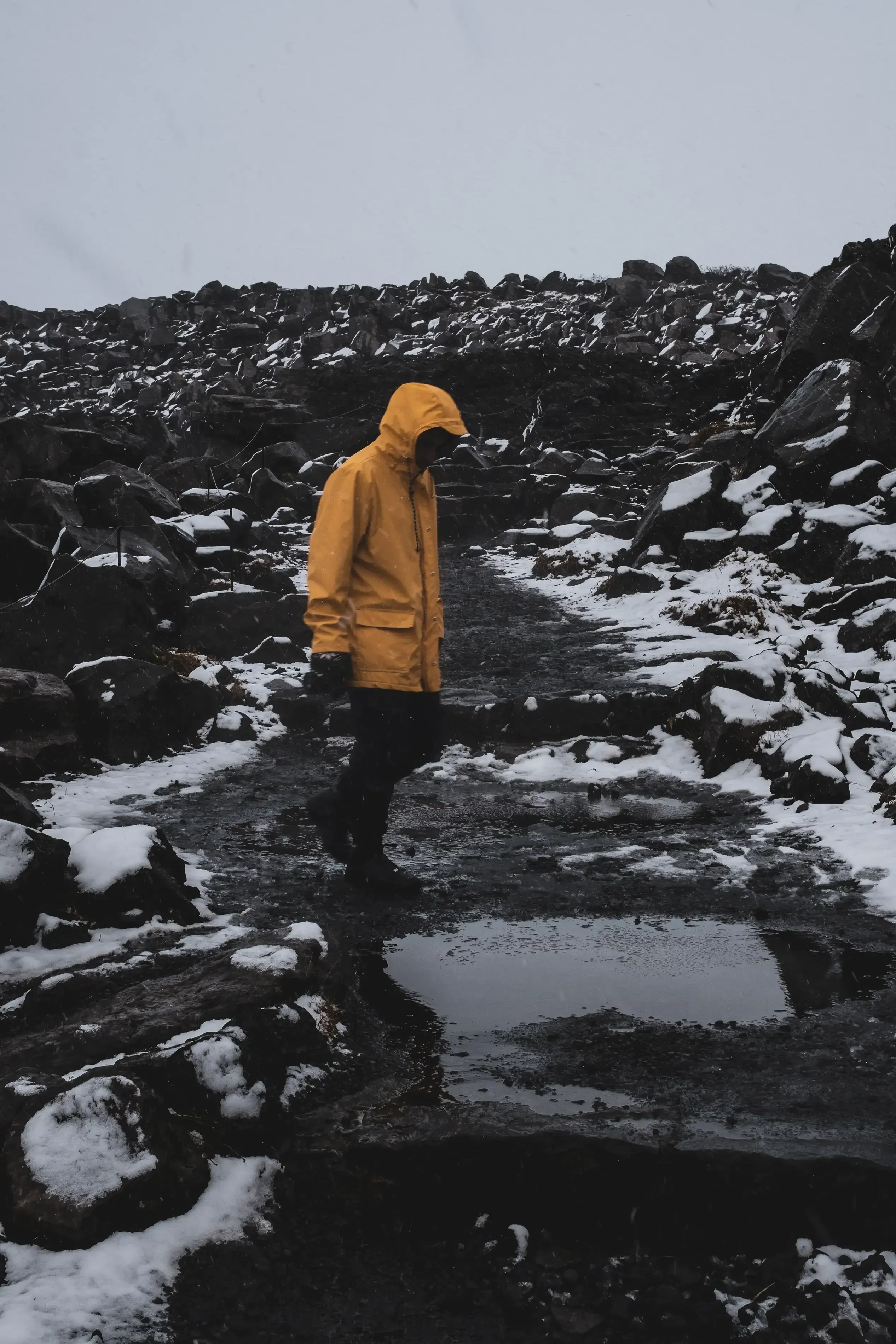 Ieser walking in a blizzard or heavy snowstorm to reach a distant waterfall.