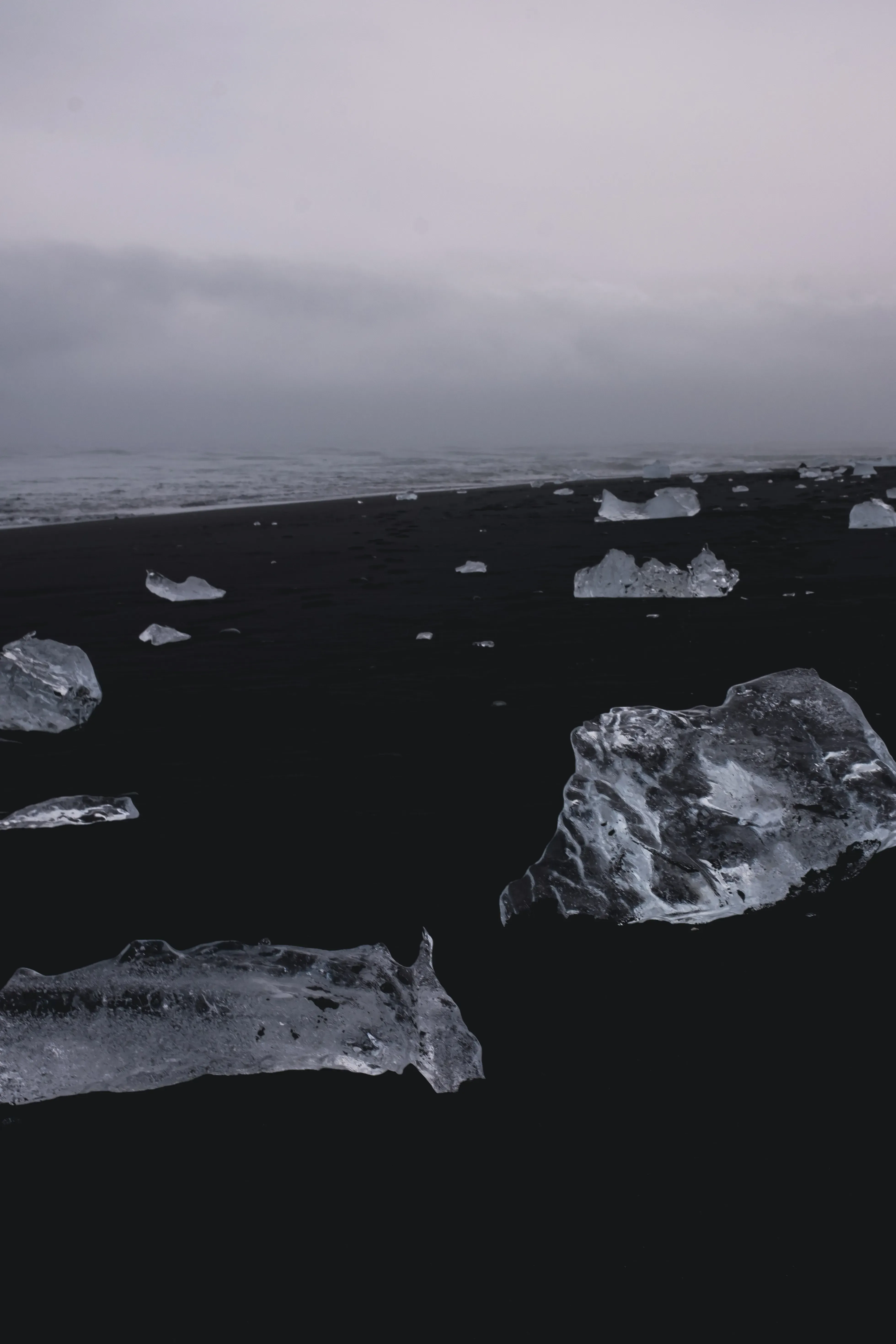 Transparent chunks of glacial ice scattered like diamonds on the black sands of Diamond Beach (Jökulsárlón).