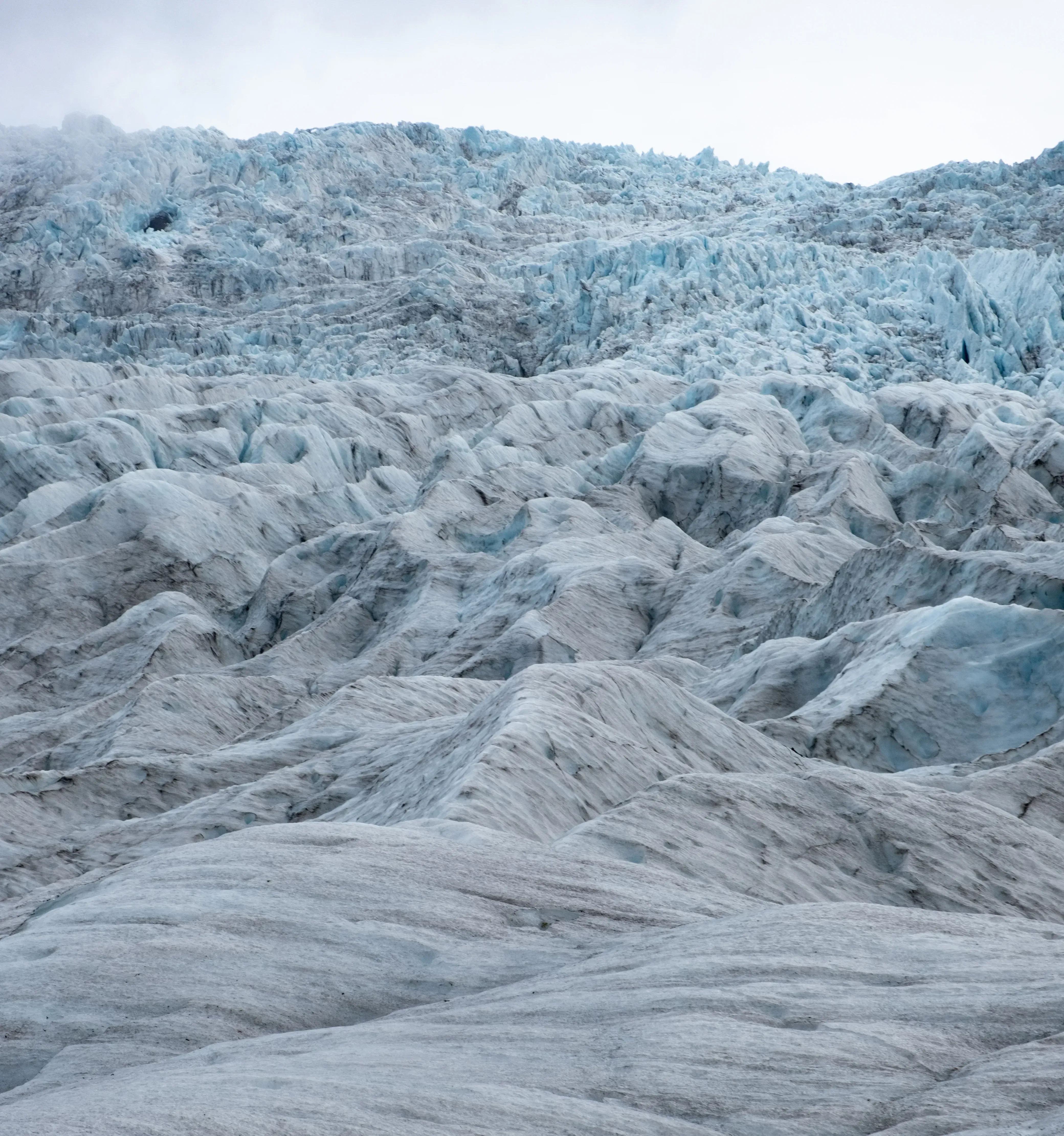 Close-up view of the dense, blue ice formation and texture of the Hvannadalshnjúkur glacier.