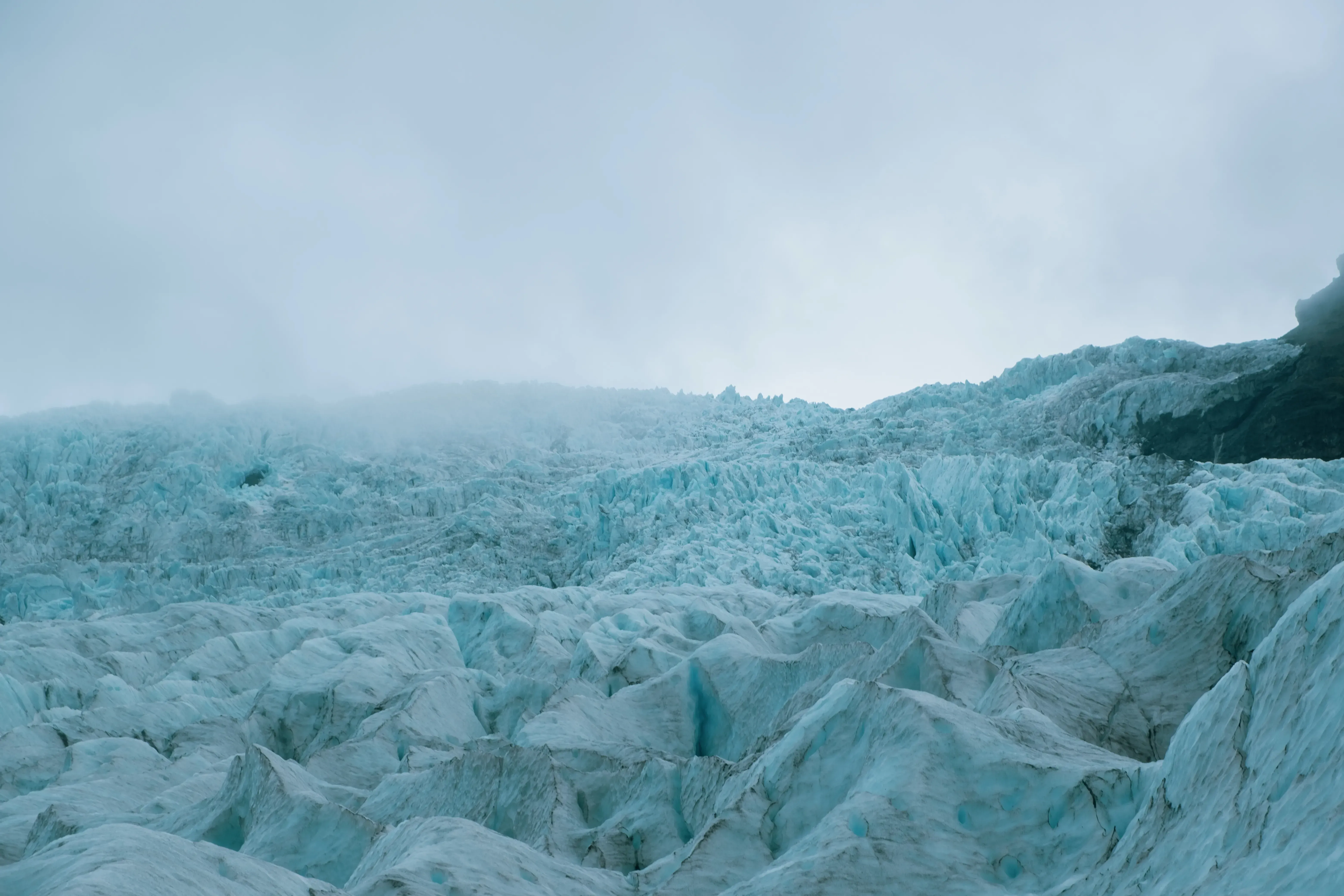 Dense fog or low clouds hanging over and partially concealing the peak of Hvannadalshnjúkur glacier.