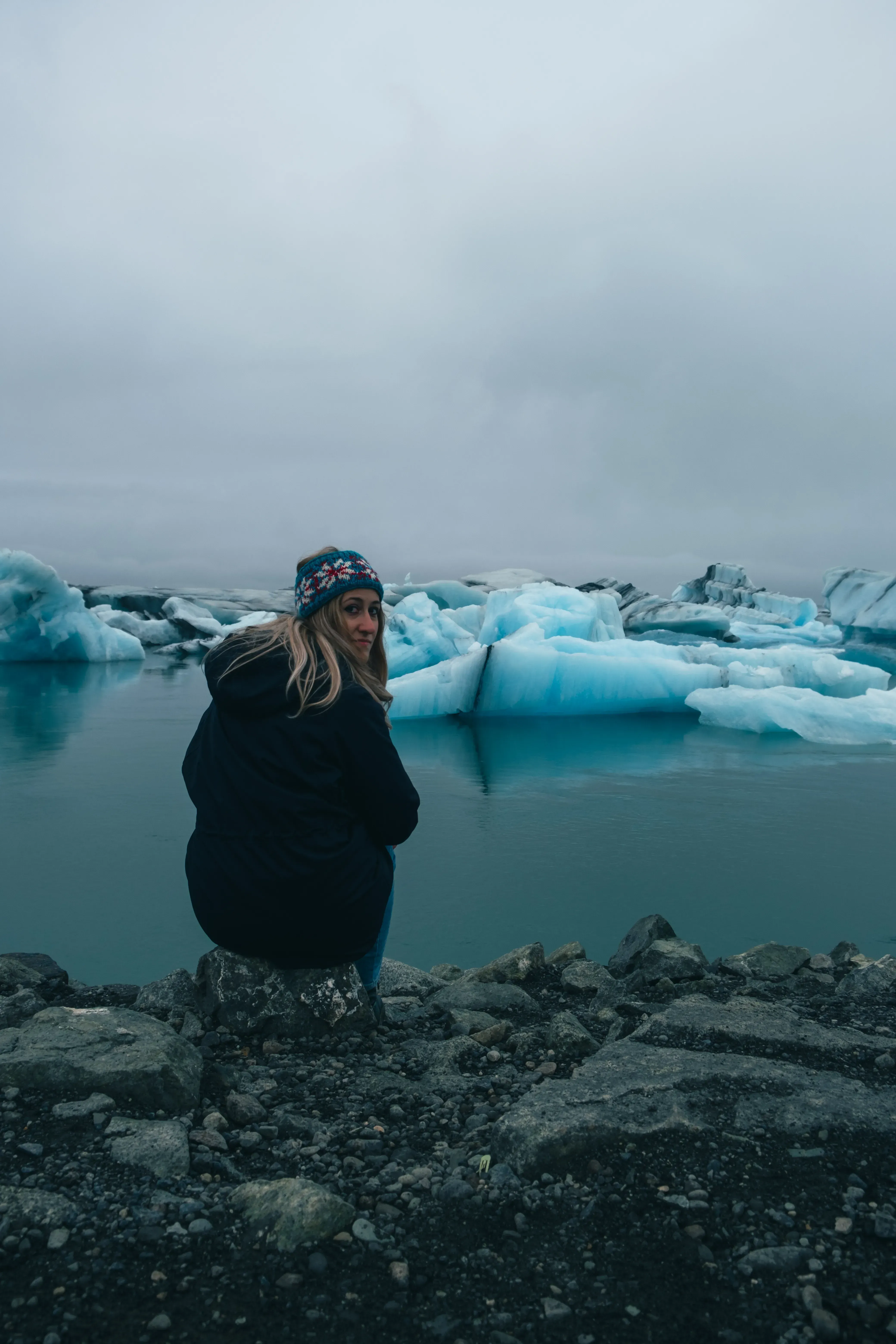 Letizia observing the large chunks of translucent glacier ice scattered on the black sand of Diamond Beach.