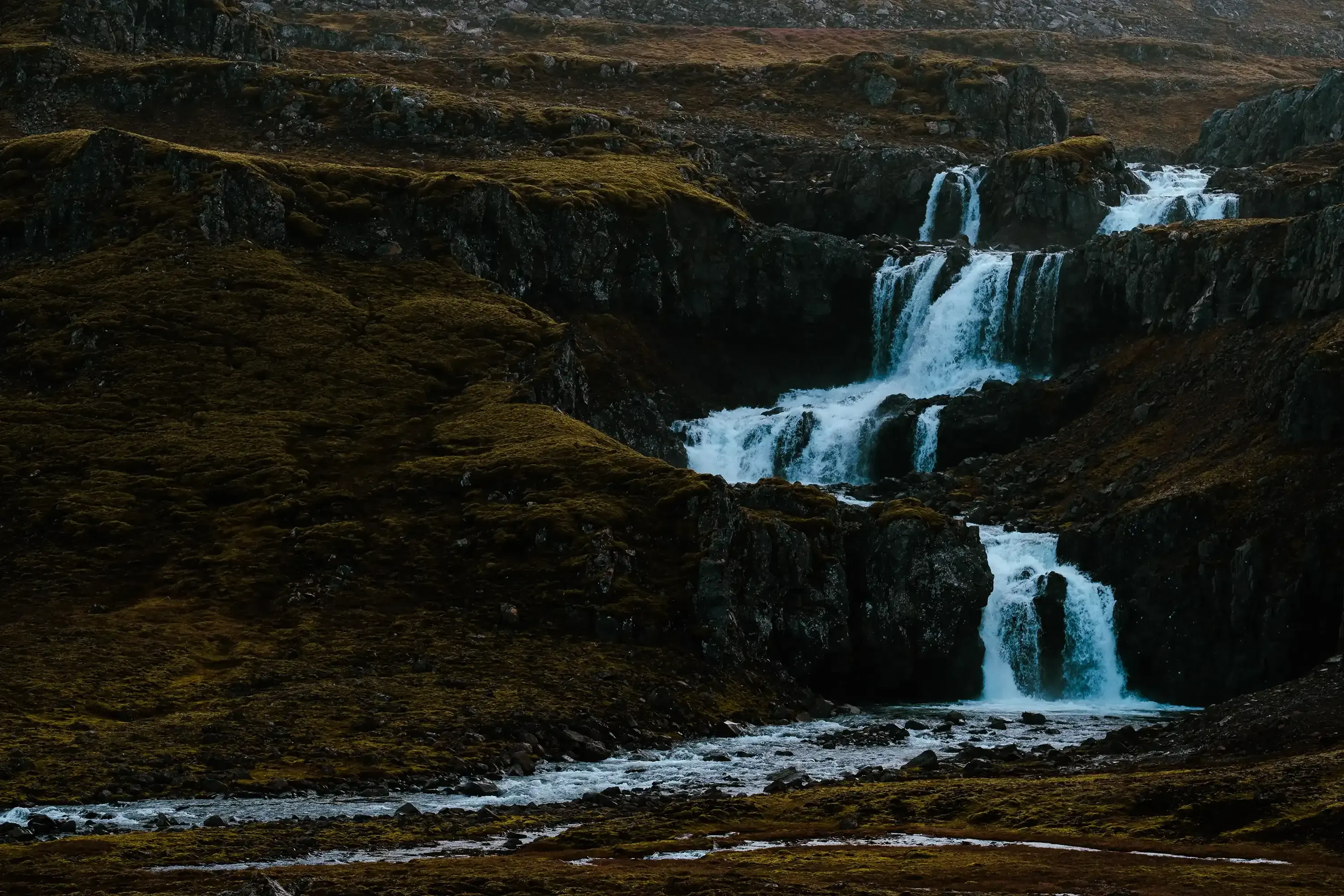 A powerful waterfall cascading down rocky cliffs deep in the interior highlands of Iceland.