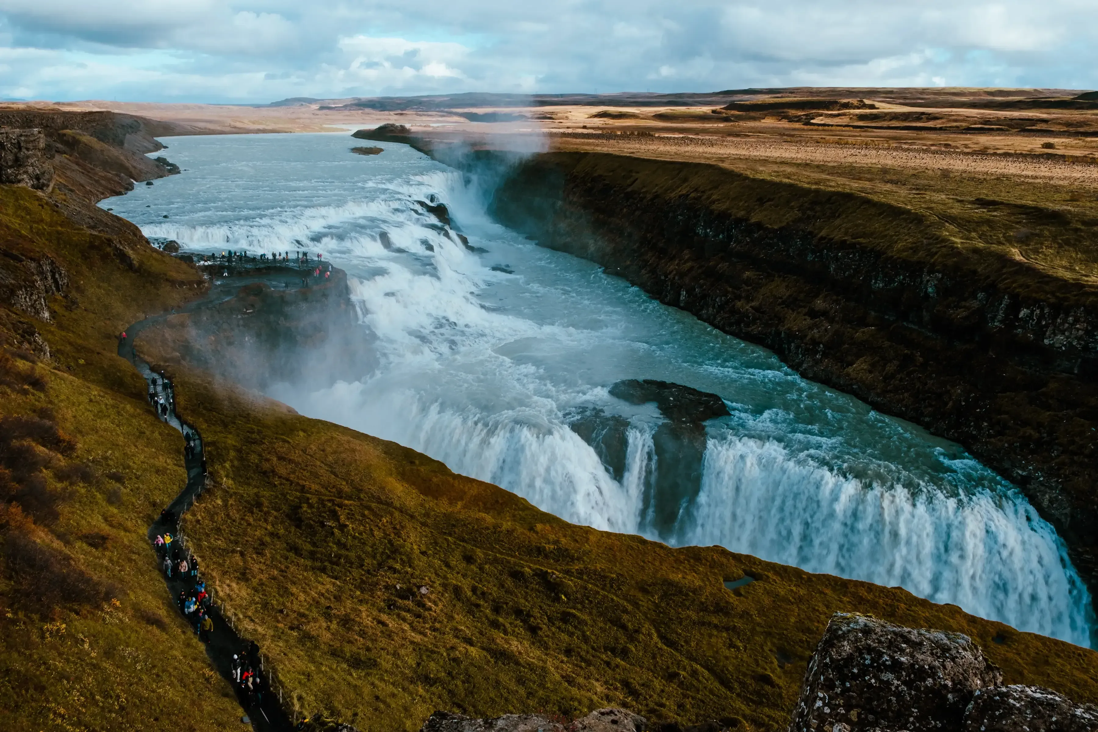 The immense, tiered Gullfoss waterfall, showing its powerful flow into the canyon.