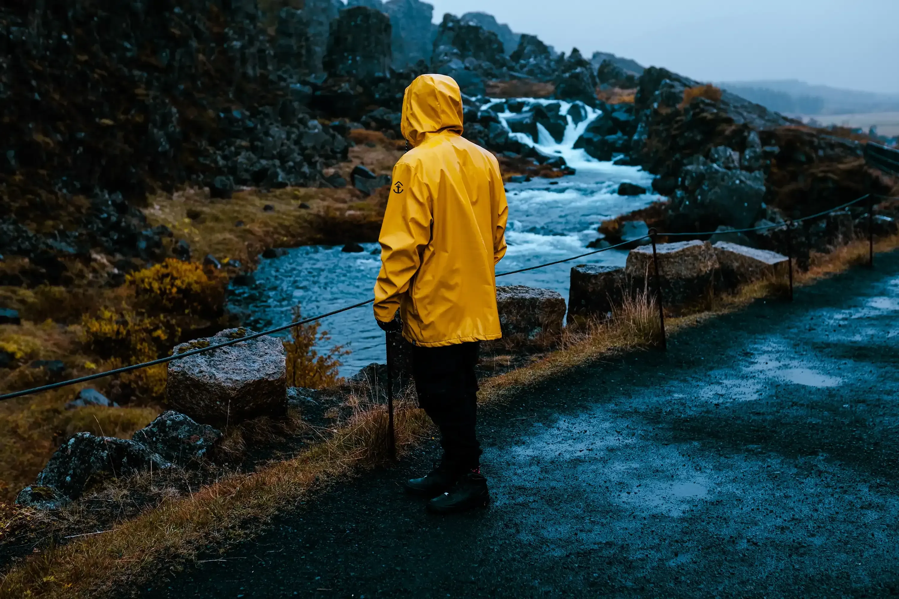 Ieser looking up or observing a small waterfall in the Icelandic landscape.