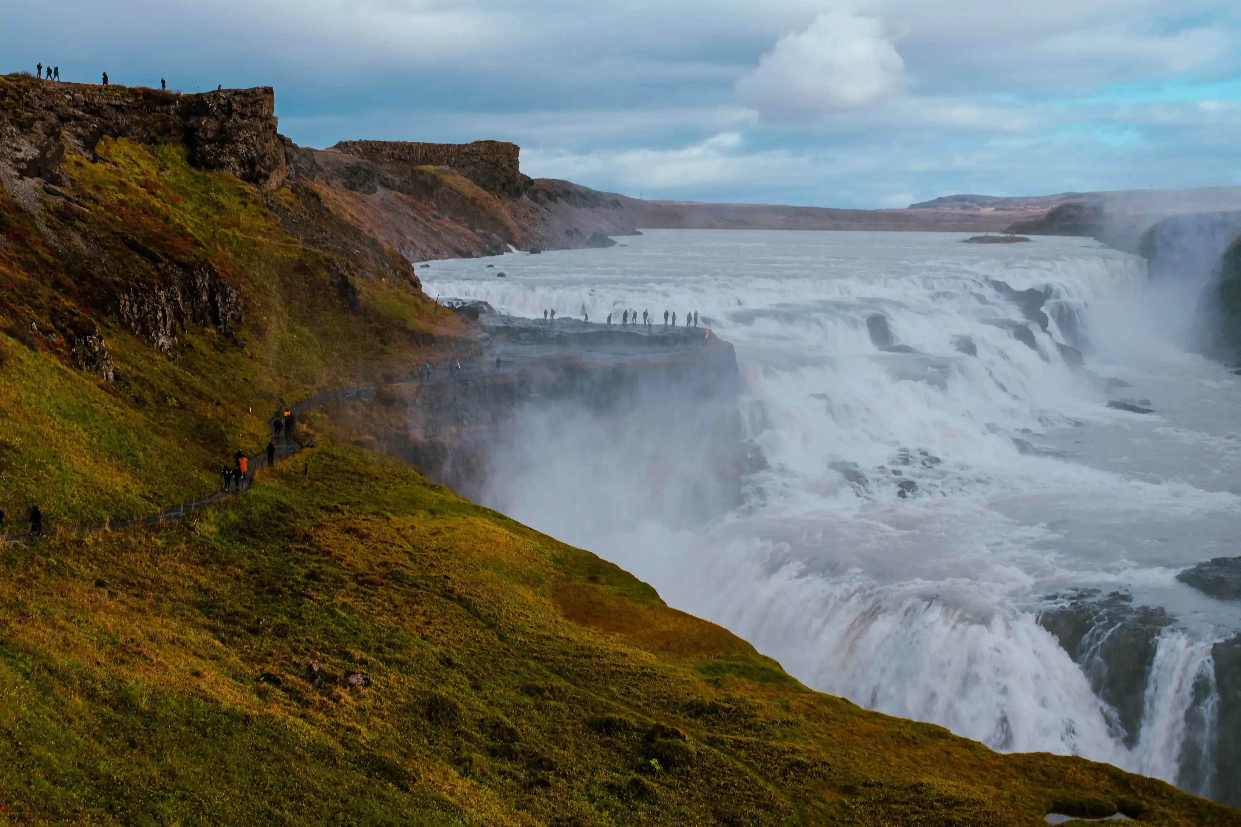 A close-up view of the powerful, churning water and spray at the edge of the Gullfoss waterfall.
