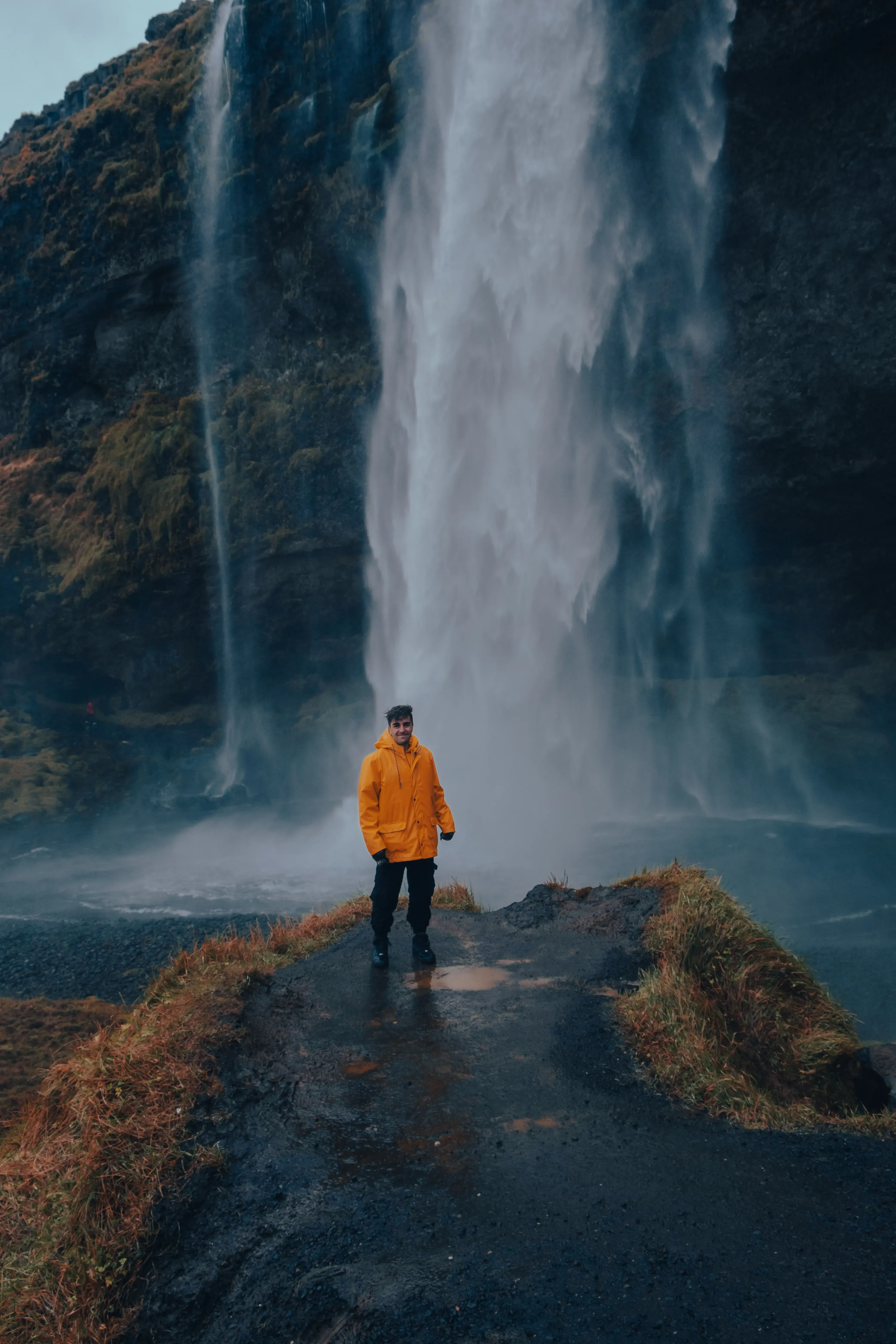 Ieser standing at the base of the Seljalandsfoss waterfall.