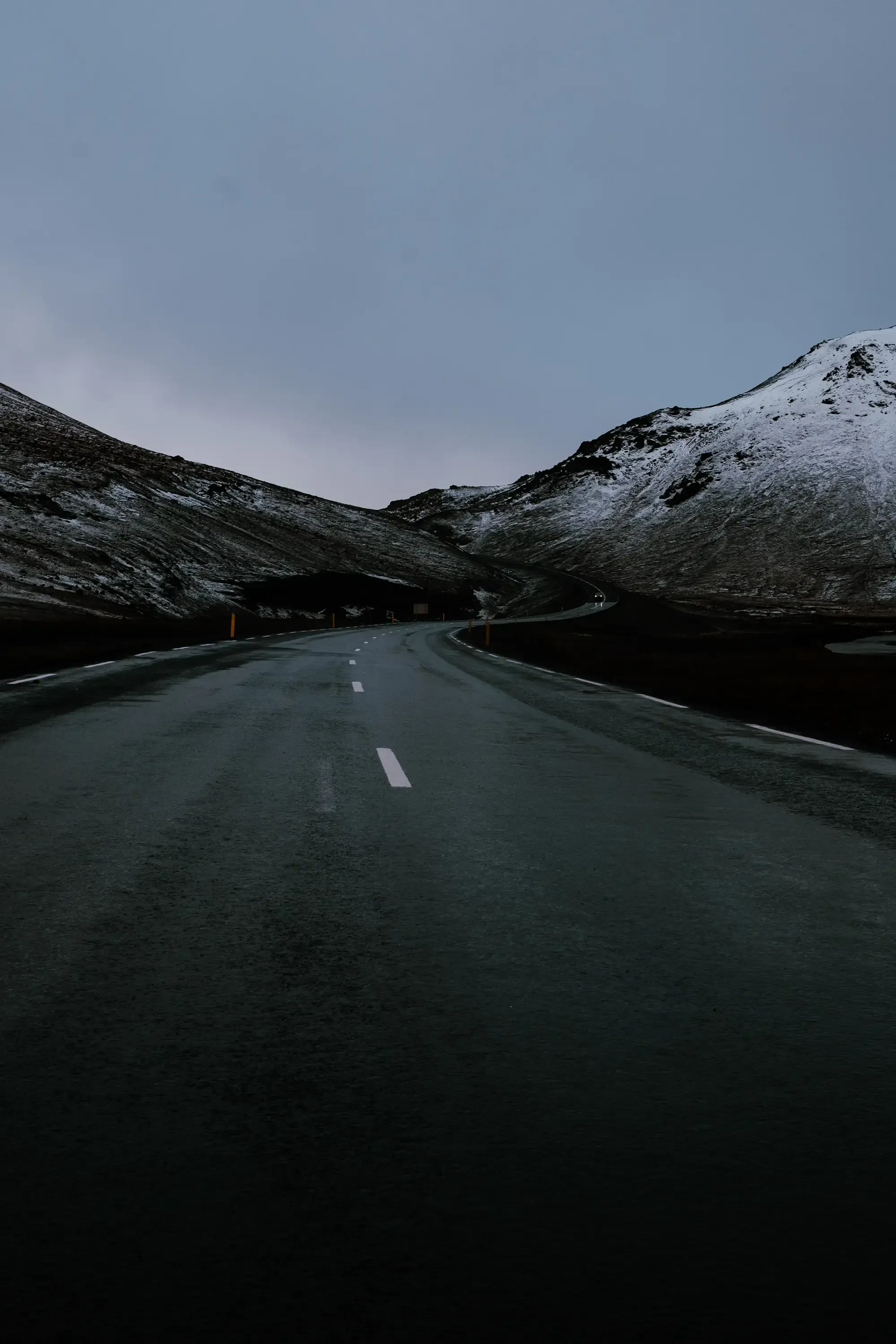 A road winding through the high, rugged mountain range of Iceland.