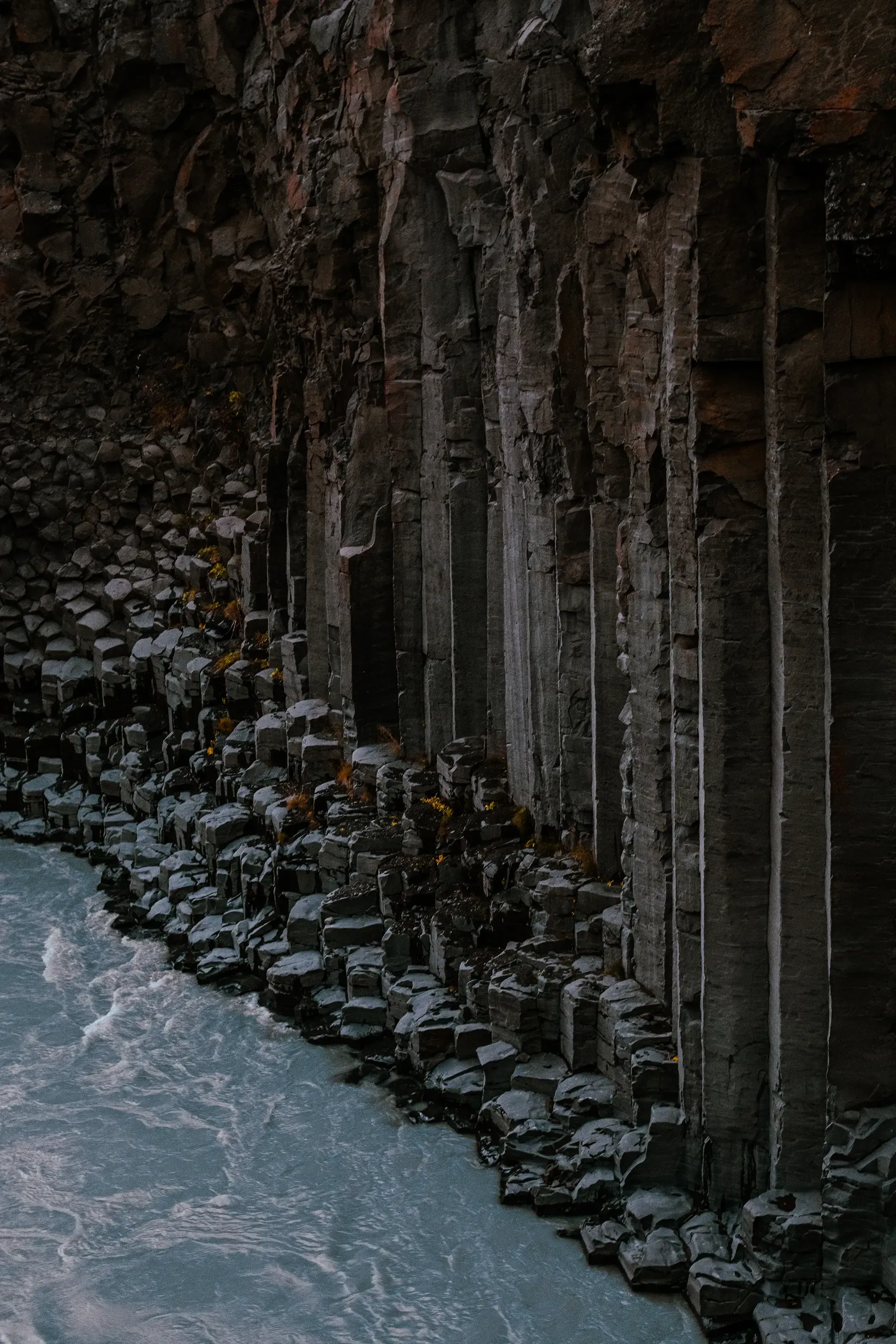 Close-up view of the perfectly formed, towering hexagonal basalt columns within the Stuðlagil Canyon.
