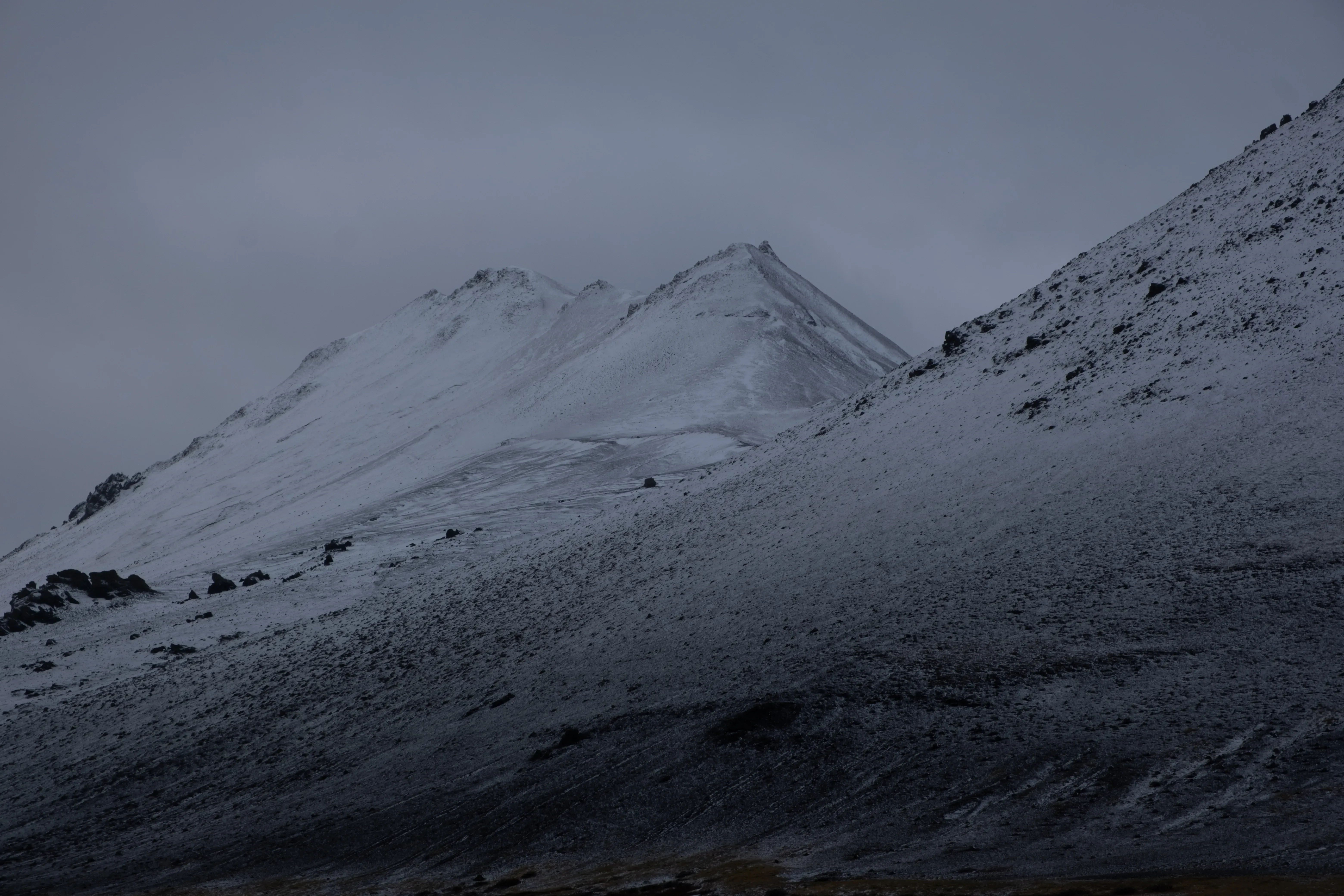large mountain peak covered with a blanket of white snow.