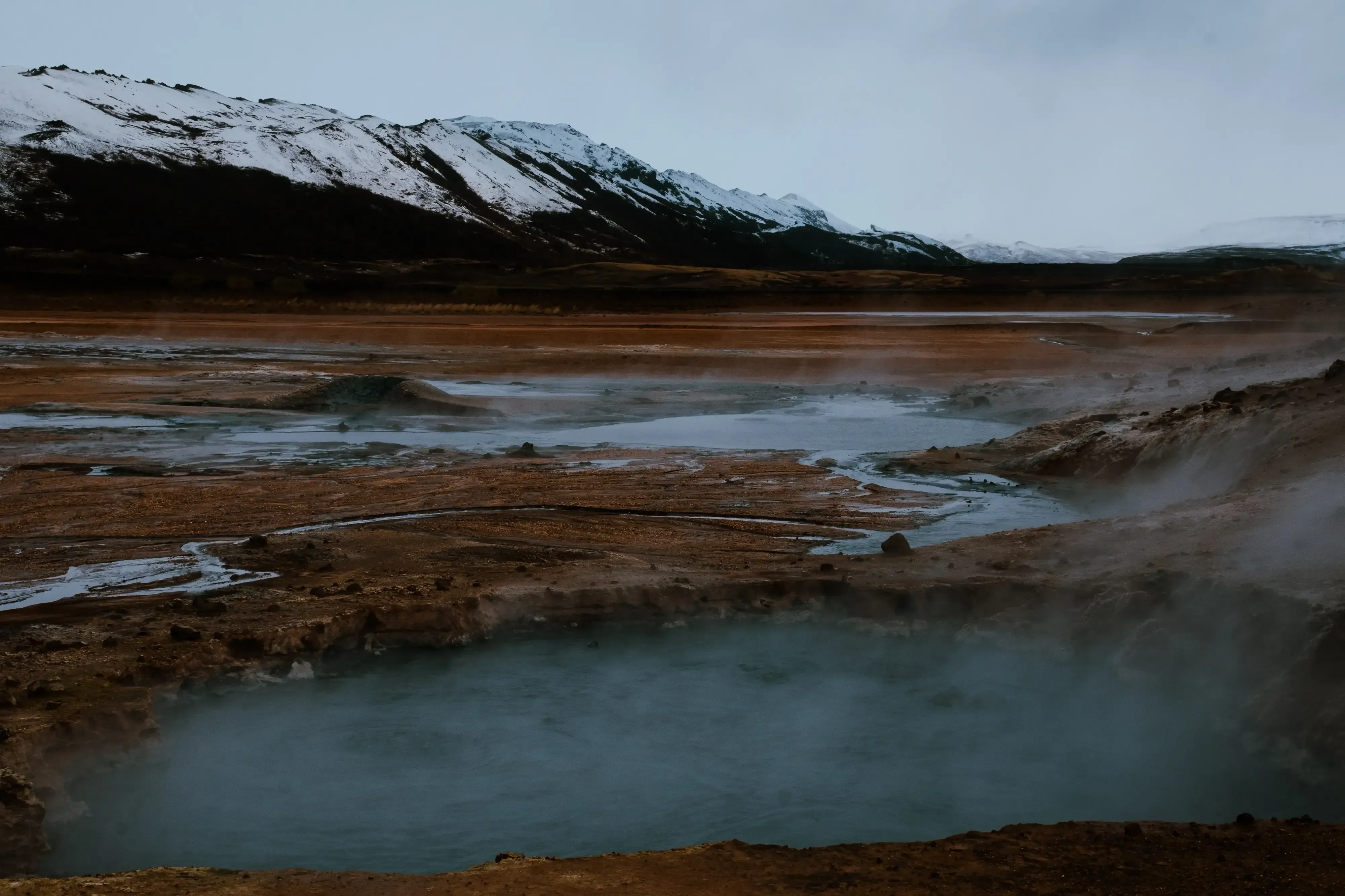 A close-up view of the ground or fissures releasing steam and hot vapor (geothermal activity).