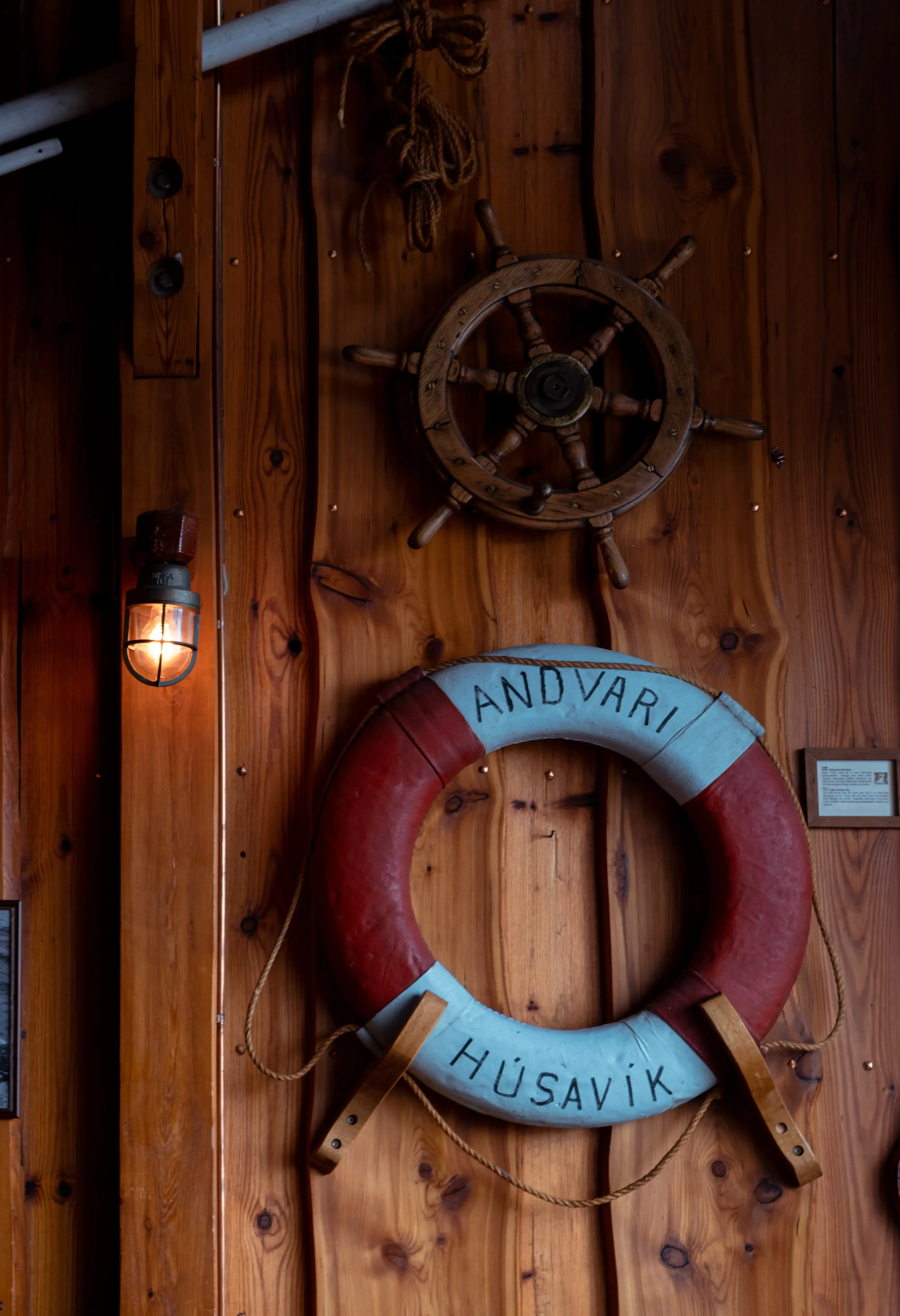 A bright orange lifebuoy or rescue ring visible near the harbor or waterfront in Húsavík.
