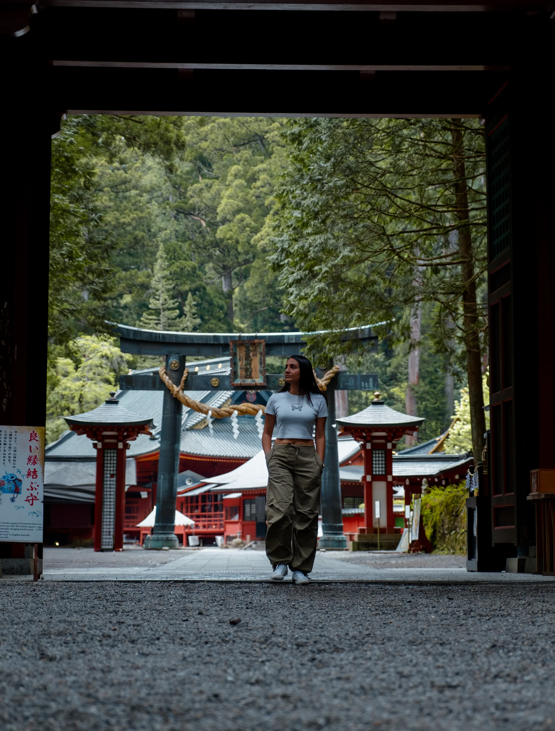 Feride walking beneath a large Torii gate at the entrance to the Nikko shrines