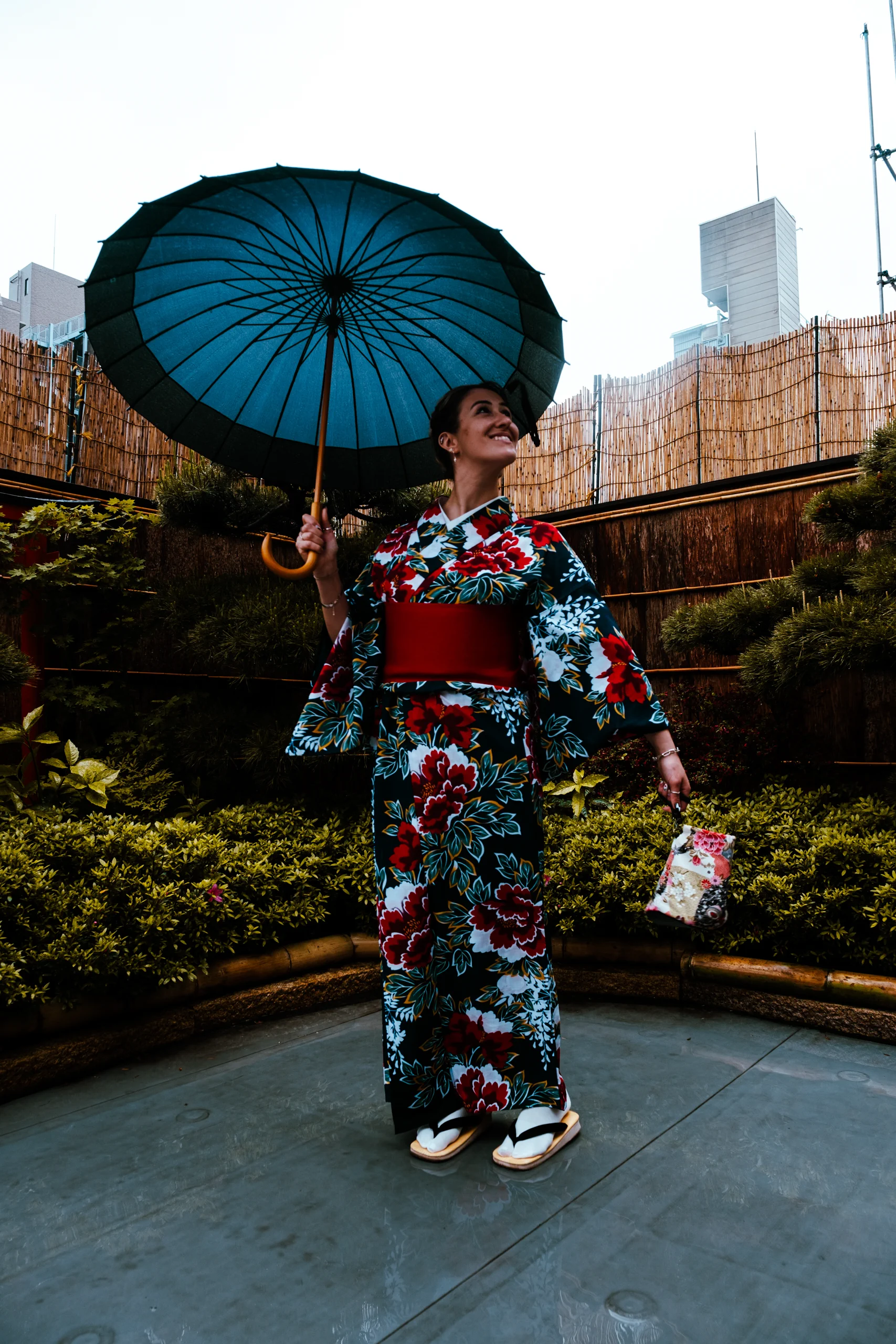 Letizia holding a Japanese umbrella while wearing a kimono in the rain