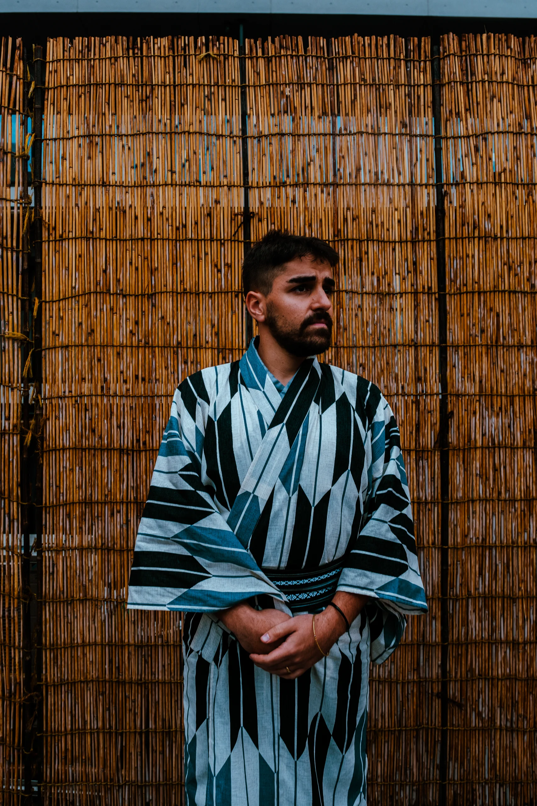 Ieser in a blue and white kimono after a tea ceremony with a reed screen background