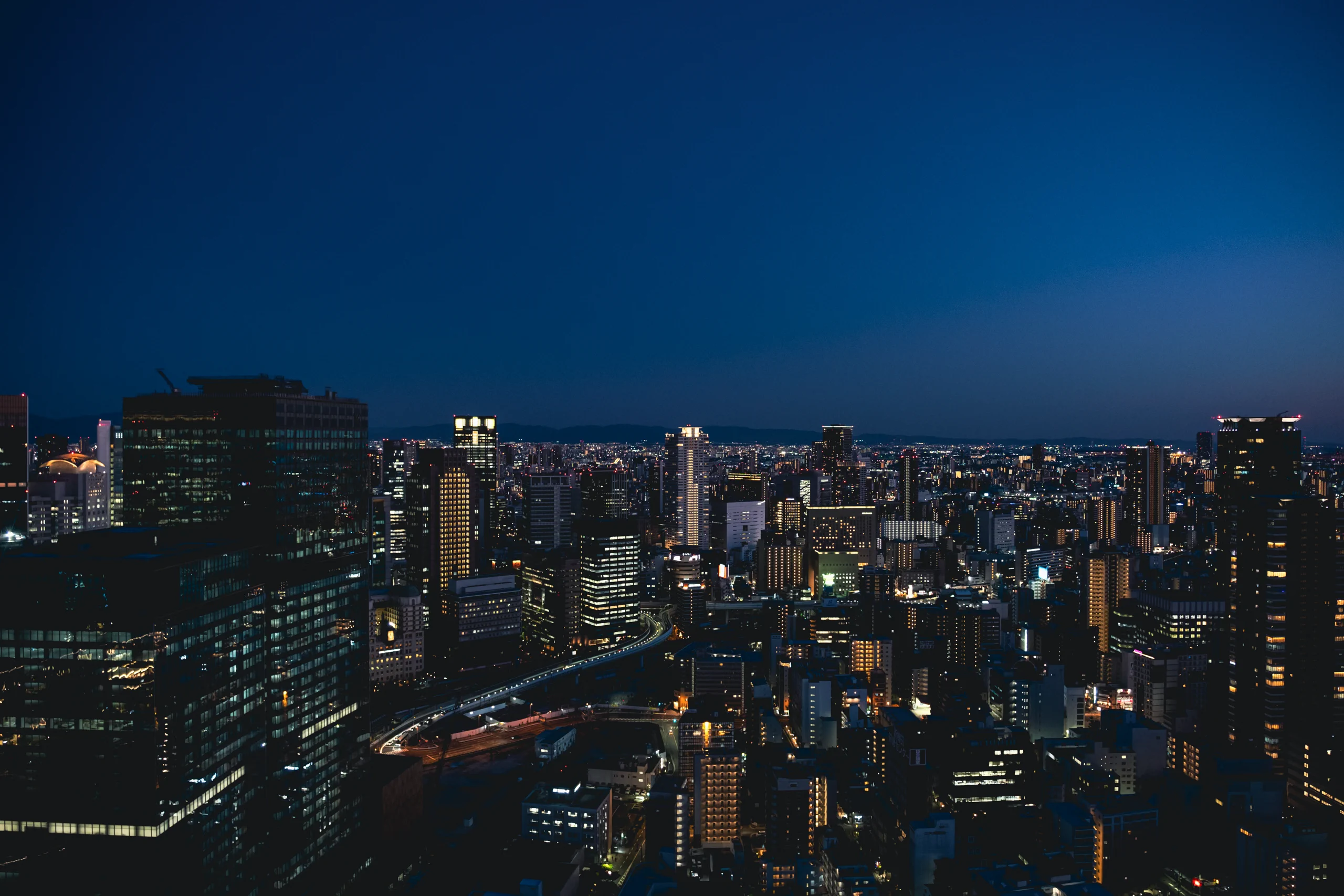 Panoramic night view of the Osaka city skyline from a skyscraper