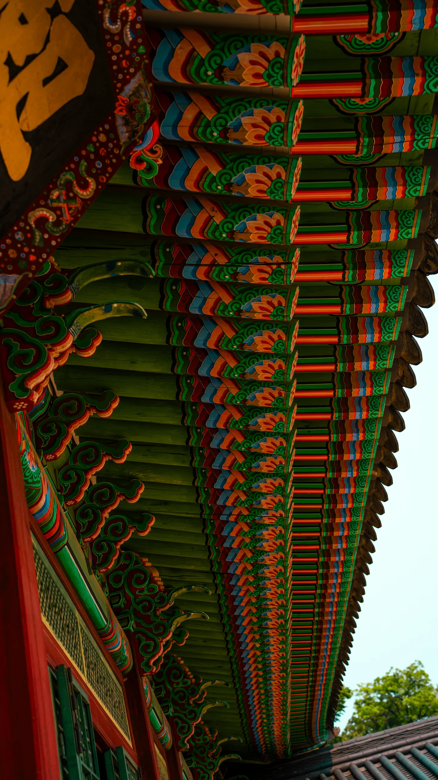 Close-up of the traditional orange and green painted ceiling inside a Gyeongbokgung Palace