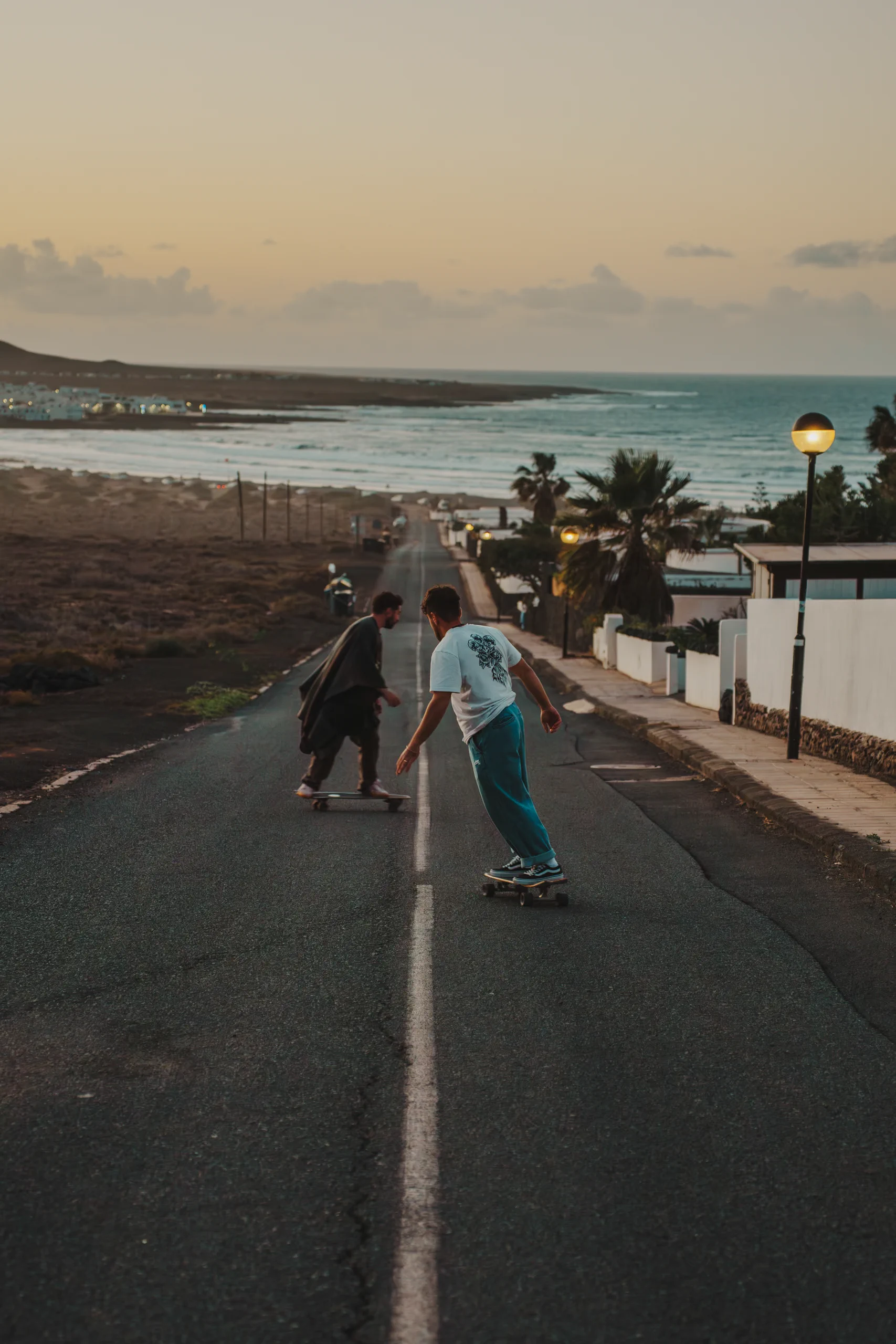 Ieser and Iair going down a road with two skateboards