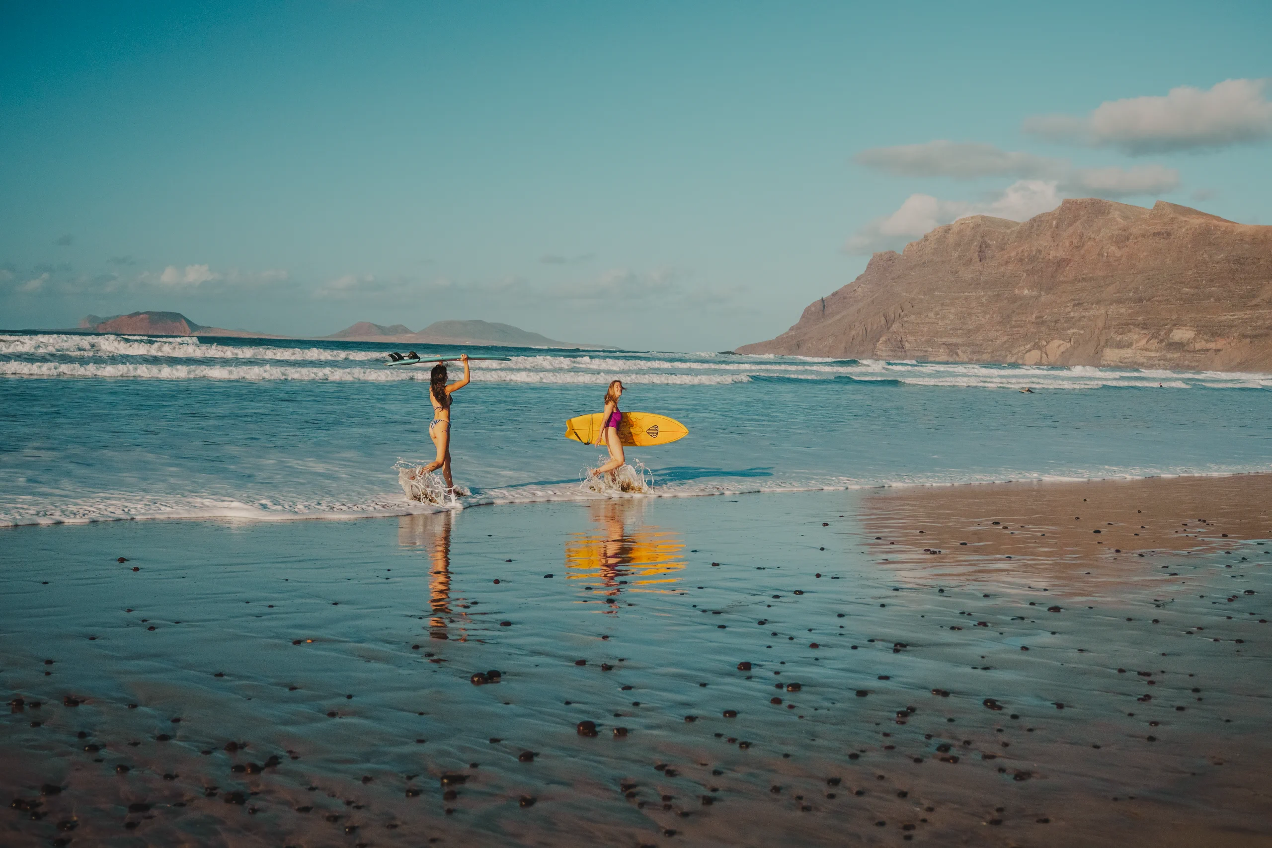 Miriam and Letizia running with two surf boards