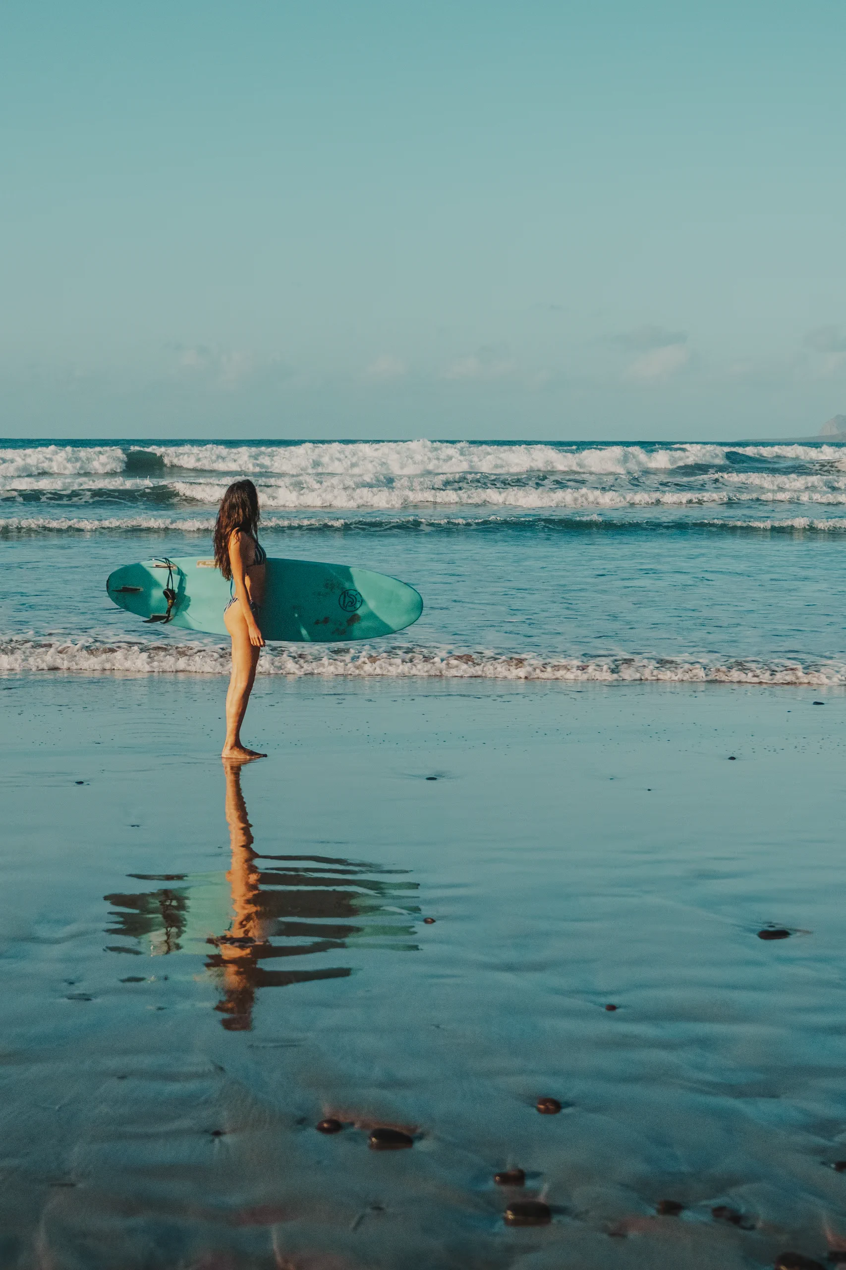 Miriam looking at the sea with a surfboard in the hands