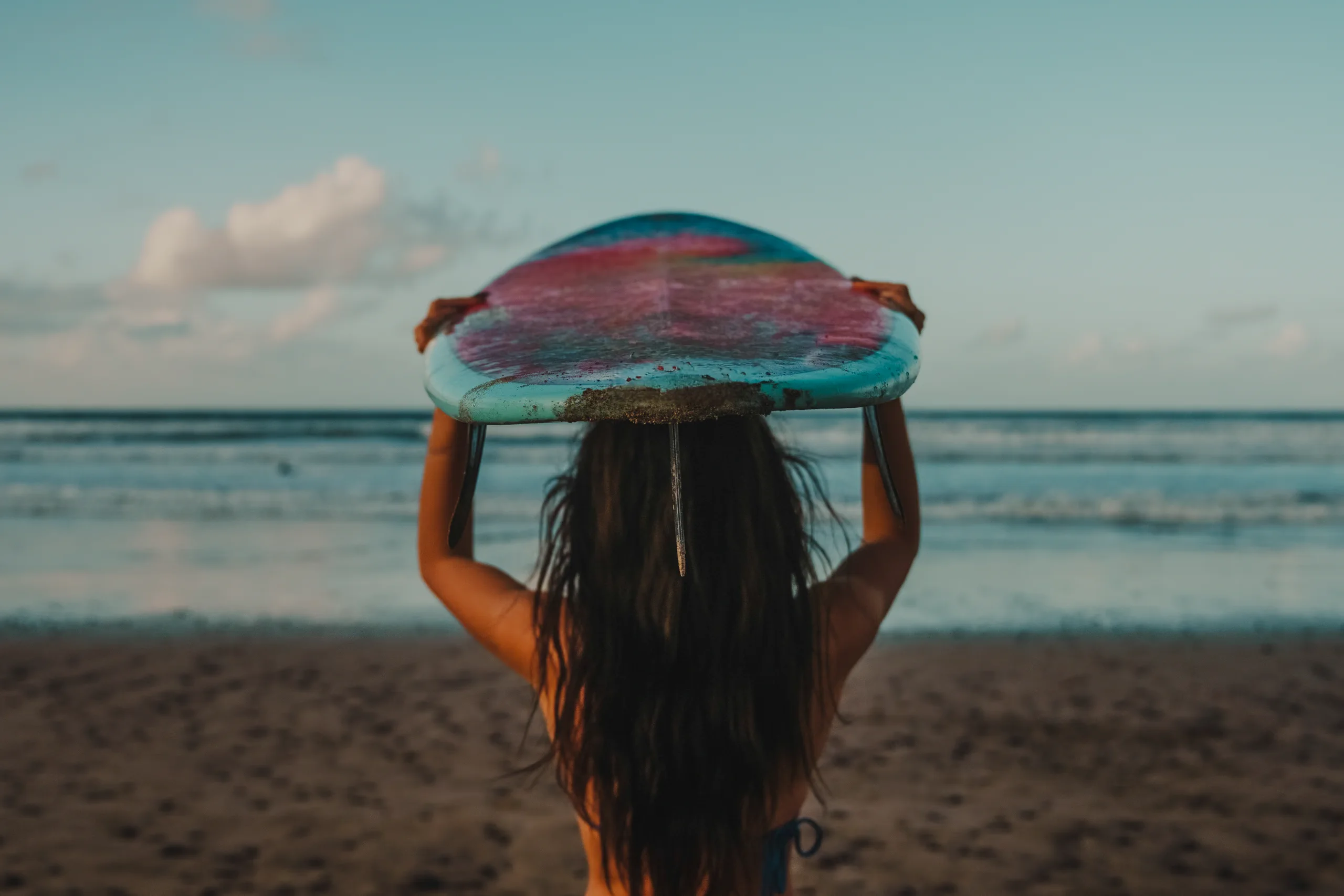MIriam with a board above her head in Famara beach
