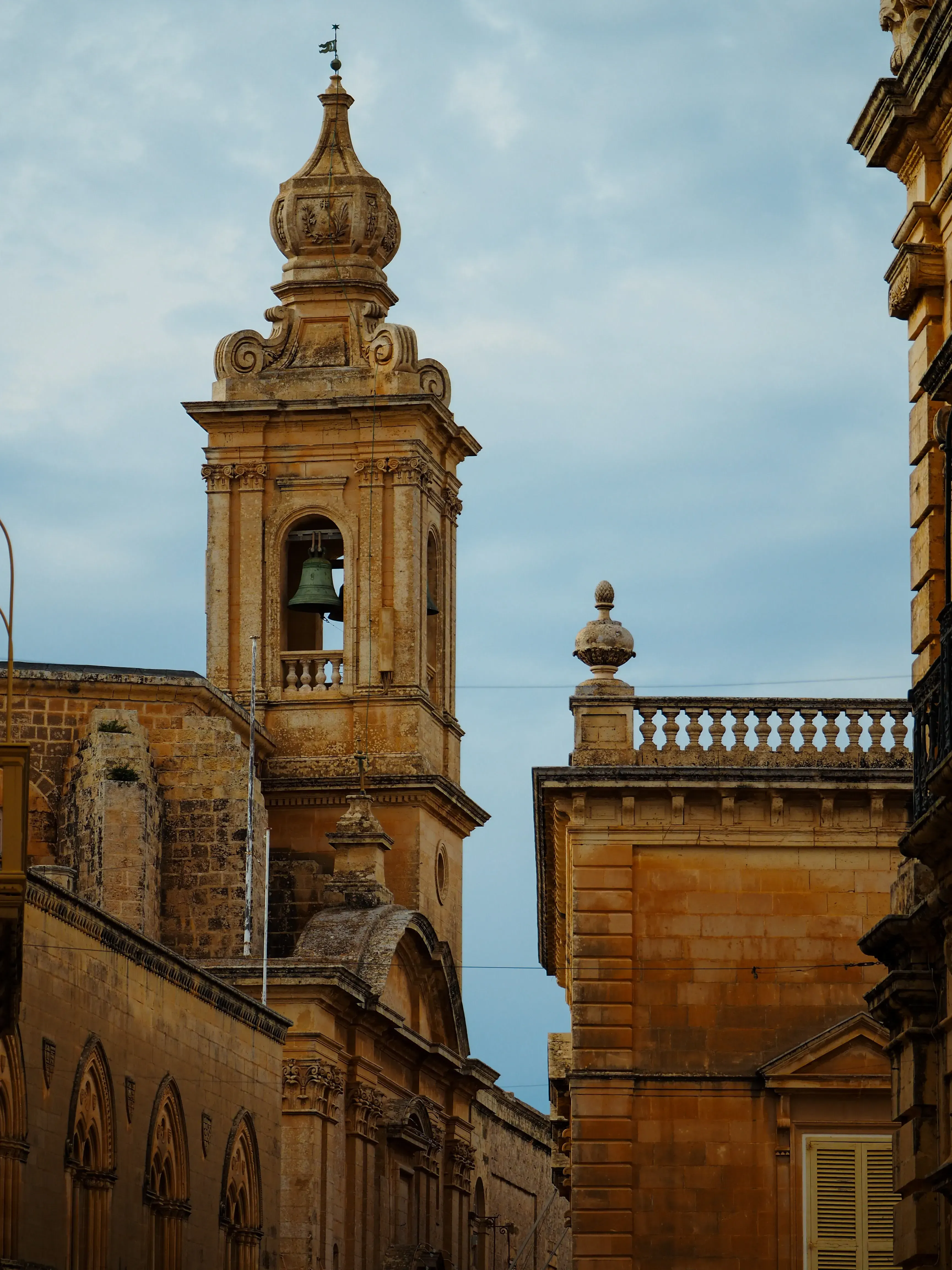 The ornate bell tower of the main Cathedral rising above the rooftops of Mdina